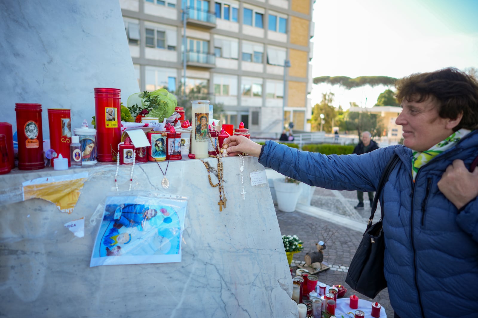 People pray for Pope Francis in front of the Agostino Gemelli Polyclinic, in Rome, Tuesday, March 11, 2025, where the Pontiff is hospitalized since Friday, Feb. 14. (AP Photo/Andrew Medichini)