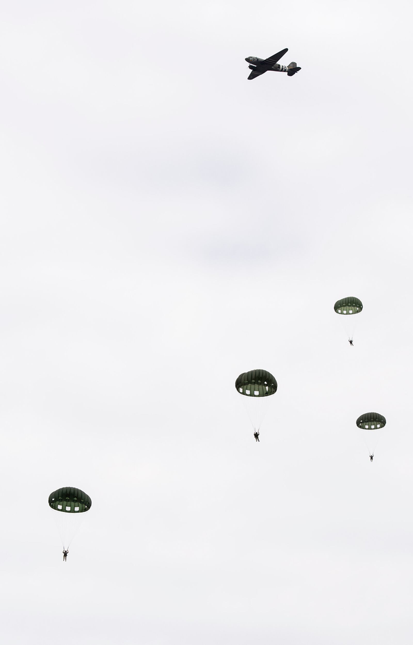 Members of a World War II airborne demonstration team participate in a mass parachute jump during a 100th birthday celebration for WWII veteran Jim “Pee Wee” Martin April 23 in Xenia, Ohio. U.S. AIR FORCE PHOTO/WESLEY FARNSWORTH