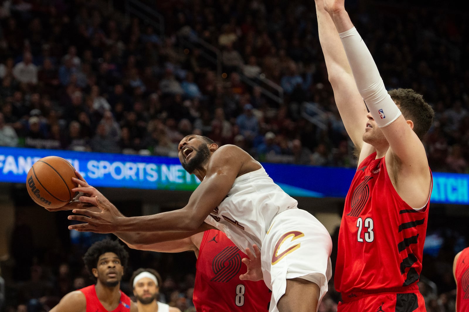 Cleveland Cavaliers' Evan Mobley, center front, grabs a rebound as Portland Trail Blazers' Donovan Clingan (23) and Deni Avdija (8) defend during the second half of an NBA basketball game in Cleveland, Sunday, March 2, 2025. (AP Photo/Phil Long)