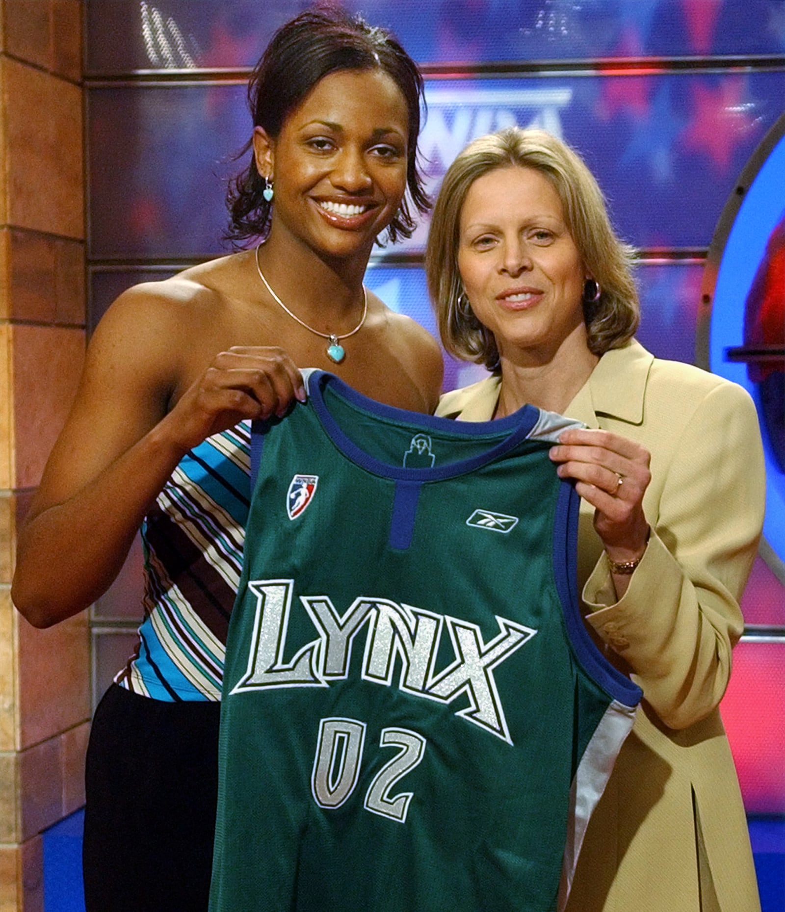 Connecticut's Tamika Williams, left, was chosen as the number six pick in the WNBA draft by the Minnesota Lynx Friday, April 19, 2002, in Secaucus, N.J. WNBA President Val Ackerman presents her with the Lynx jersey.  (AP Photo/Bill Kostroun)