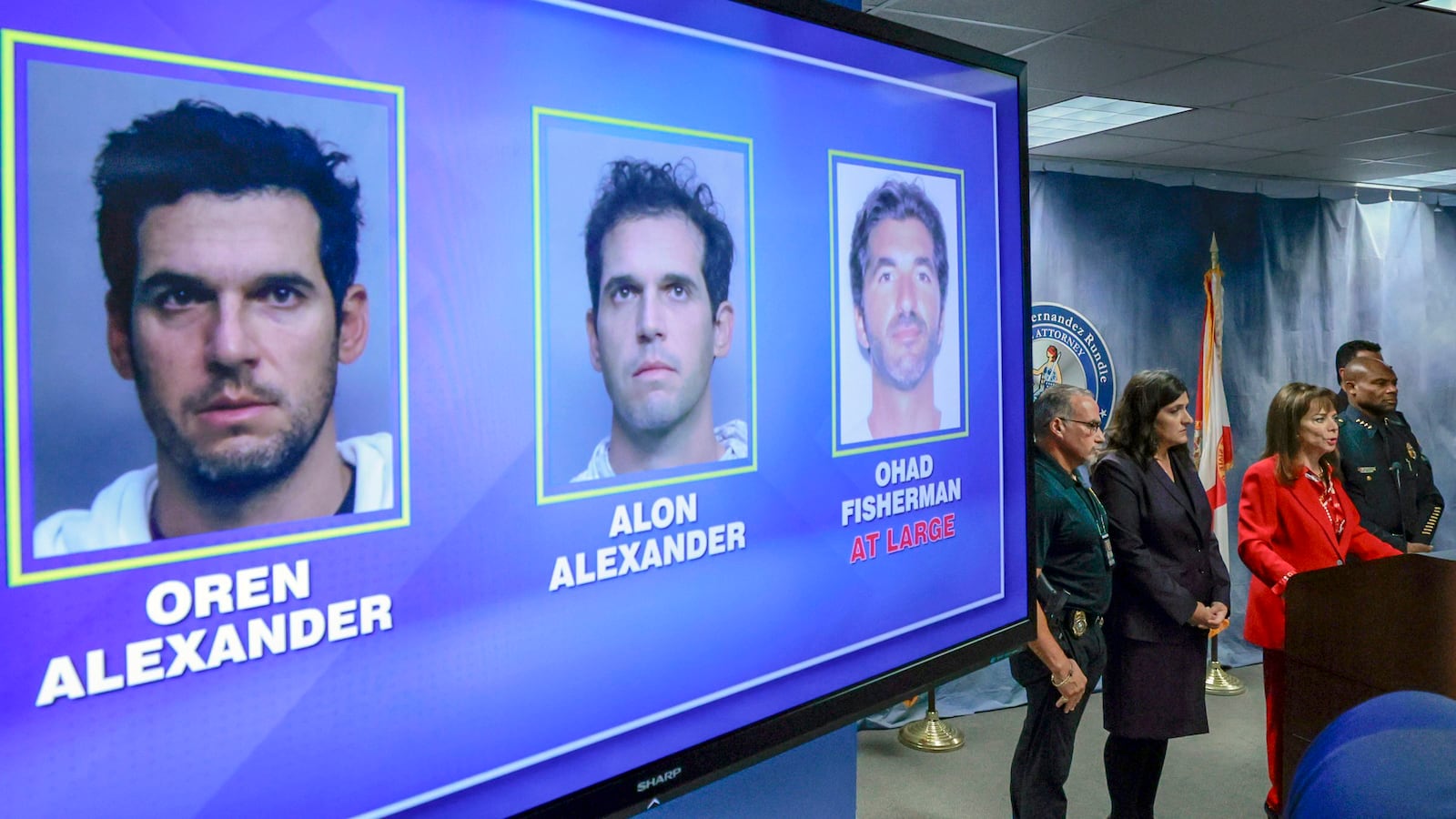 Suspects arrested or at large are displayed during State Attorney Katherine Fernandez Rundle's press conference at the State Attorney's Office, in Miami, Wednesday, Dec. 11, 2024, regarding the arrest of the Alexander twin brothers and suspect at large Ohad Fisherman for their sexual assault allegations in Miami Beach. (Al Diaz/Miami Herald via AP)