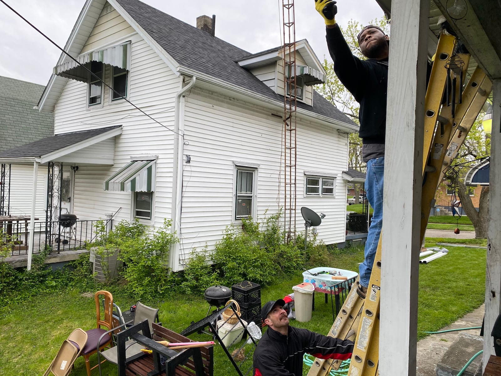 Stephen Valentine works on Marilyn Watson’s gutters at her home in Madden Hills and Jake Riley held the ladder steady. The work was done through Rebuilding Together Dayton, a local nonprofit, and the house workers were from Wilcon Corporation. EILEEN McCLORY STAFF