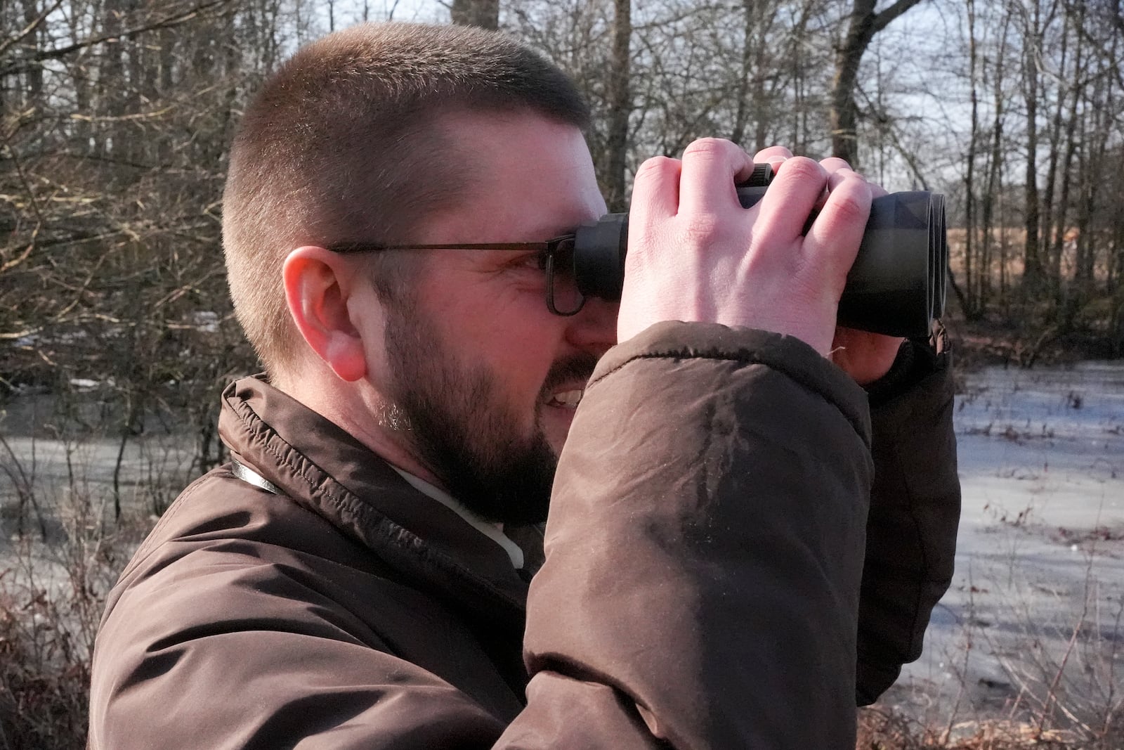 Park ranger David Young uses binoculars to get a closer look of sandhill cranes at the Wheeler National Wildlife Refuge, Monday, Jan. 13, 2025, in Decatur, Ala. (AP Photo/George Walker IV)