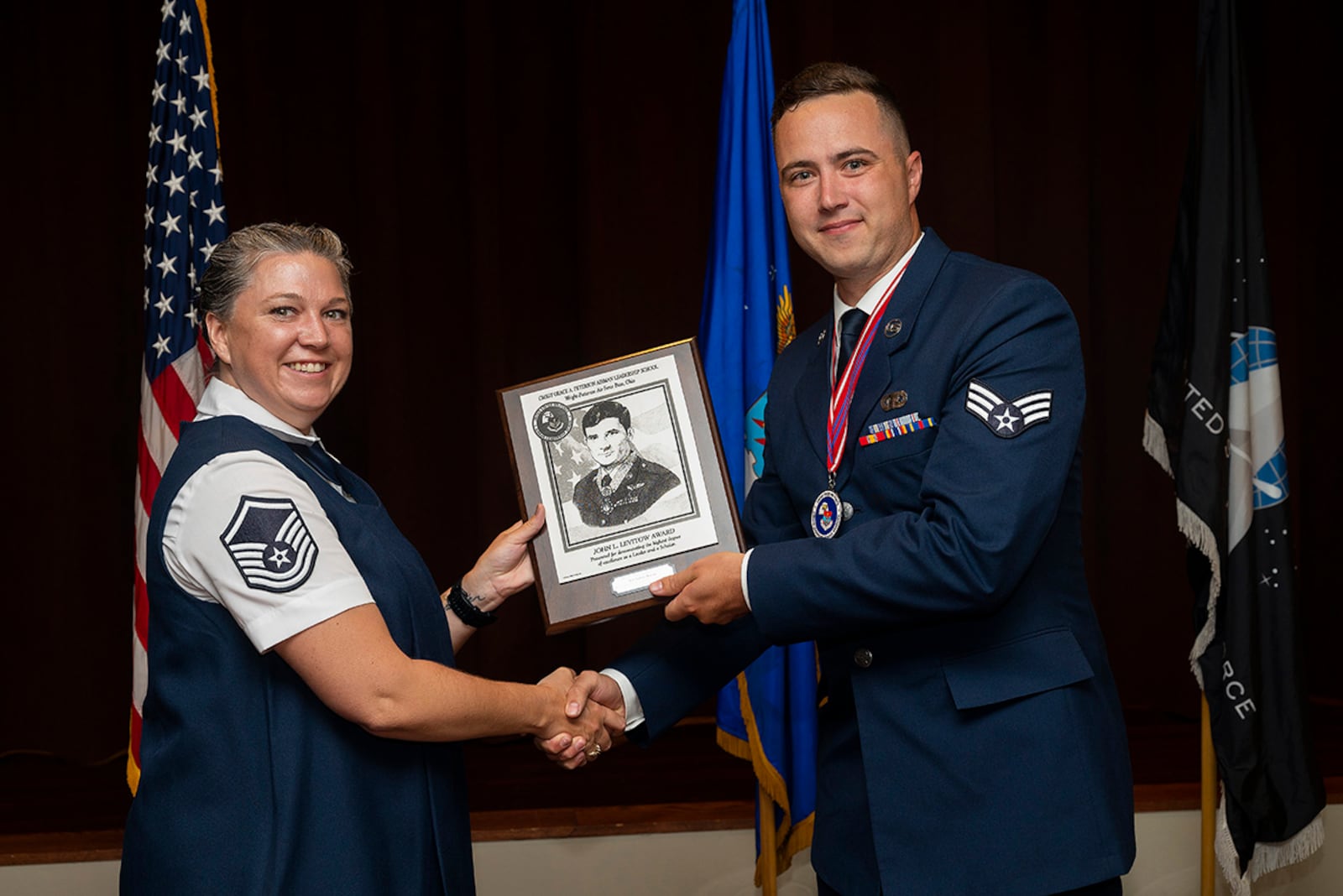 Master Sgt. Dominique Hix, Air Force Sergeants Association, presents Airman Arthur Marais, National Air and Space Intelligence Center, with the John L. Levitow Award at the Chief Master Sgt. Grace A. Peterson Airman Leadership School Class 22-E graduation ceremony on June 16, at Wright-Patterson Air Force Base, Ohio. The John L. Levitow Award goes to the class’s top graduate. U.S. AIR FORCE PHOTO/R.J. ORIEZ