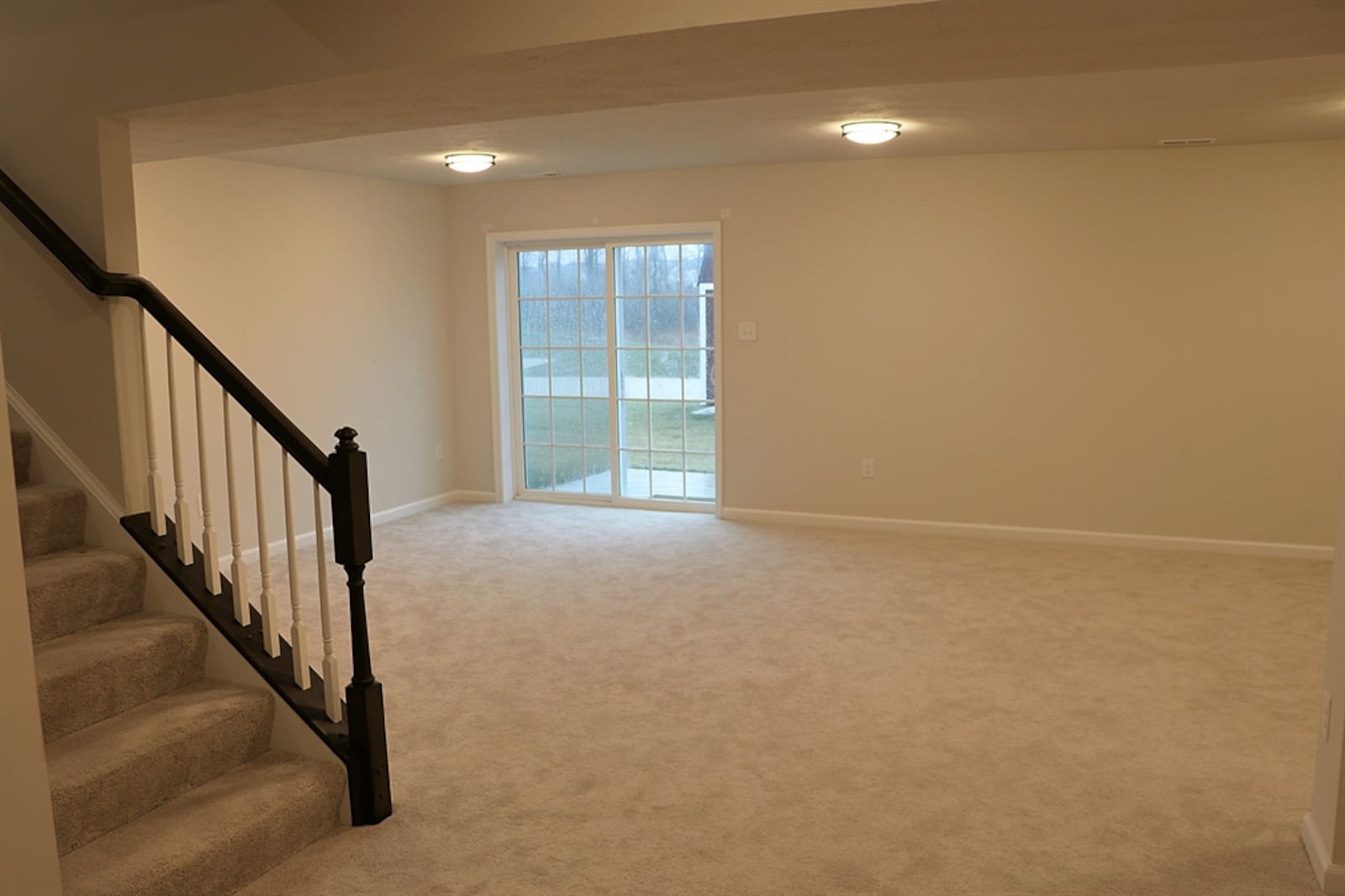 Sliding patio doors open out to a small concrete patio and the backyard.