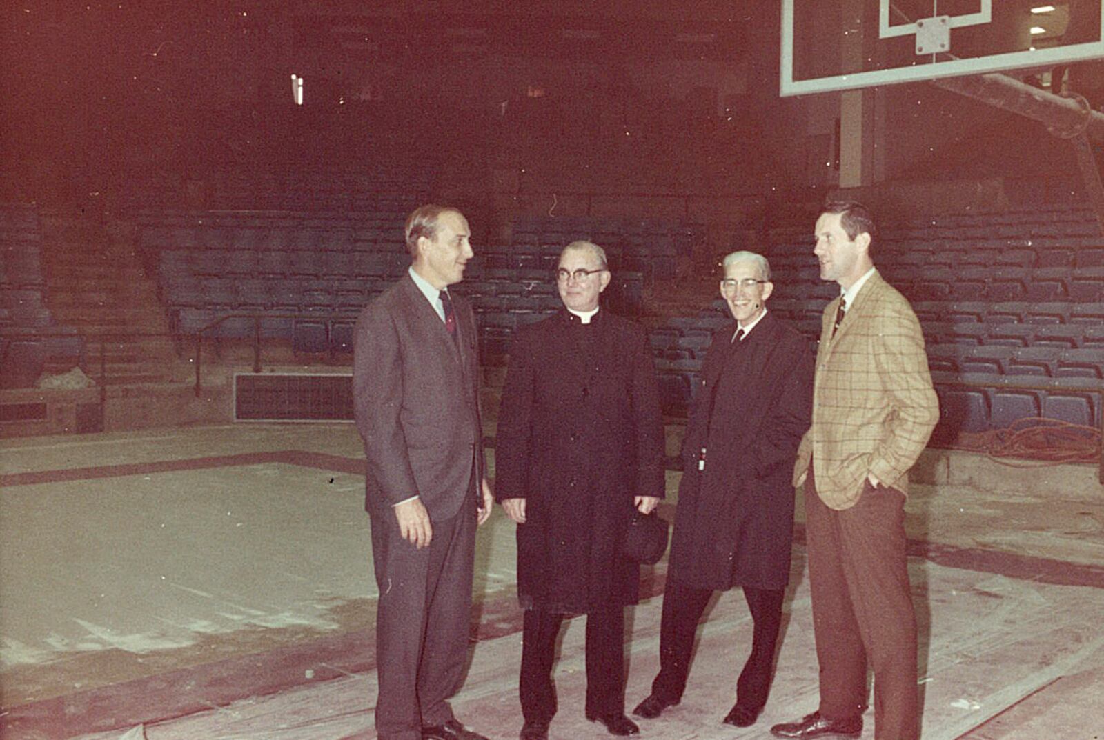 Athletic Director Tom Frericks, Rev. Father Charles Collins, Athletic Board Chair, Brother Elmer Lackner, UD’s vice president of public relations, and coach Don Donoher stand on the arena floor in 1969. Photo from Tom Frericks’ scrapbook