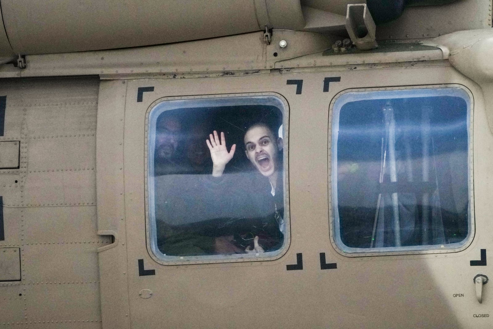 Freed Israeli hostage Omer Wenkert, gestures from a military helicopter as he arrives at Beilinson hospital in Petah Tikva, Israel, after he was released from Hamas captivity in the Gaza Strip, Saturday, Feb. 22, 2025. (AP Photo/Ariel Schalit)