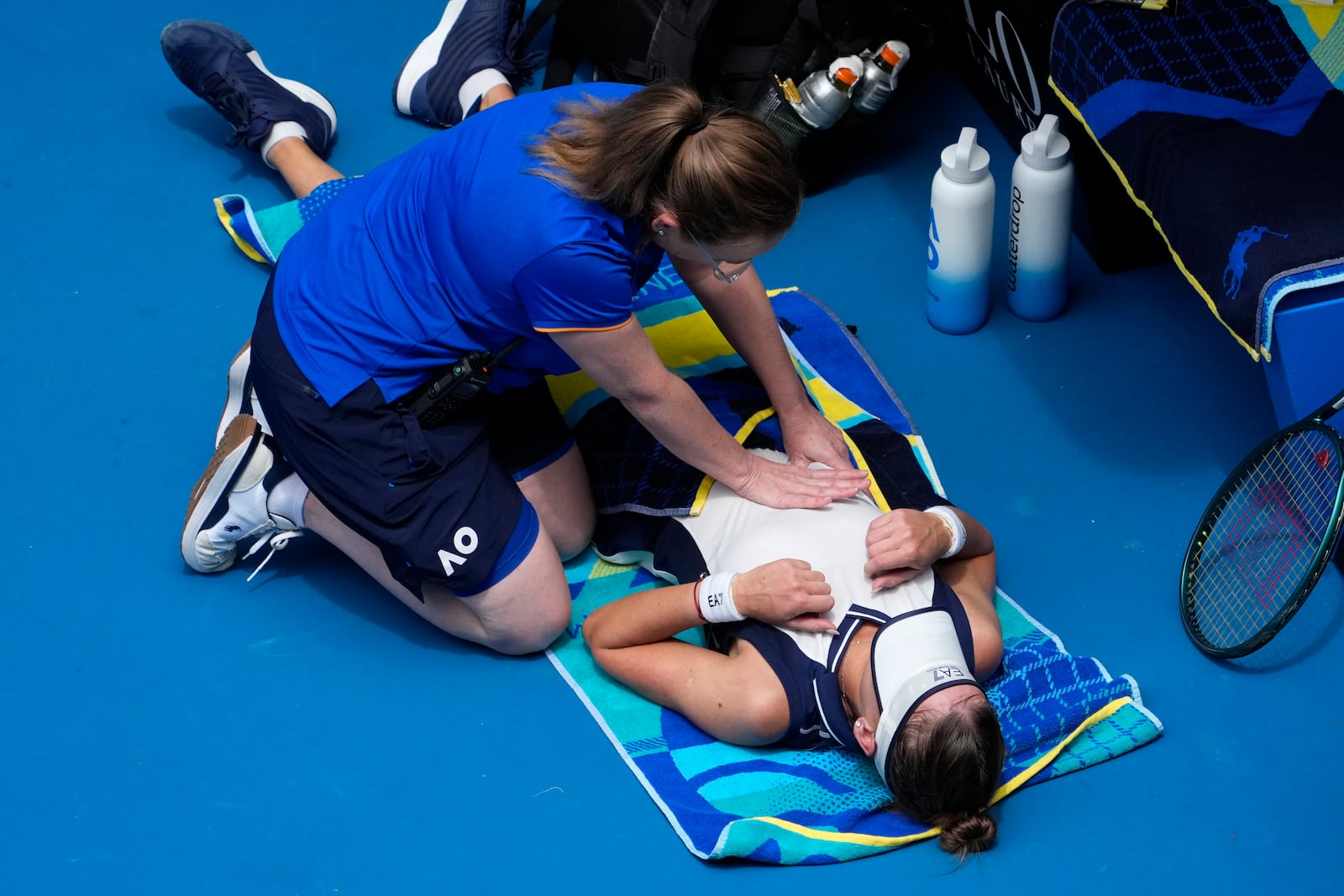 Veronika Kudermetova of Russia receives treatment from a trainer during her fourth round match against against Elina Svitolina of Ukraine at the Australian Open tennis championship in Melbourne, Australia, Monday, Jan. 20, 2025. (AP Photo/Asanka Brendon Ratnayake)