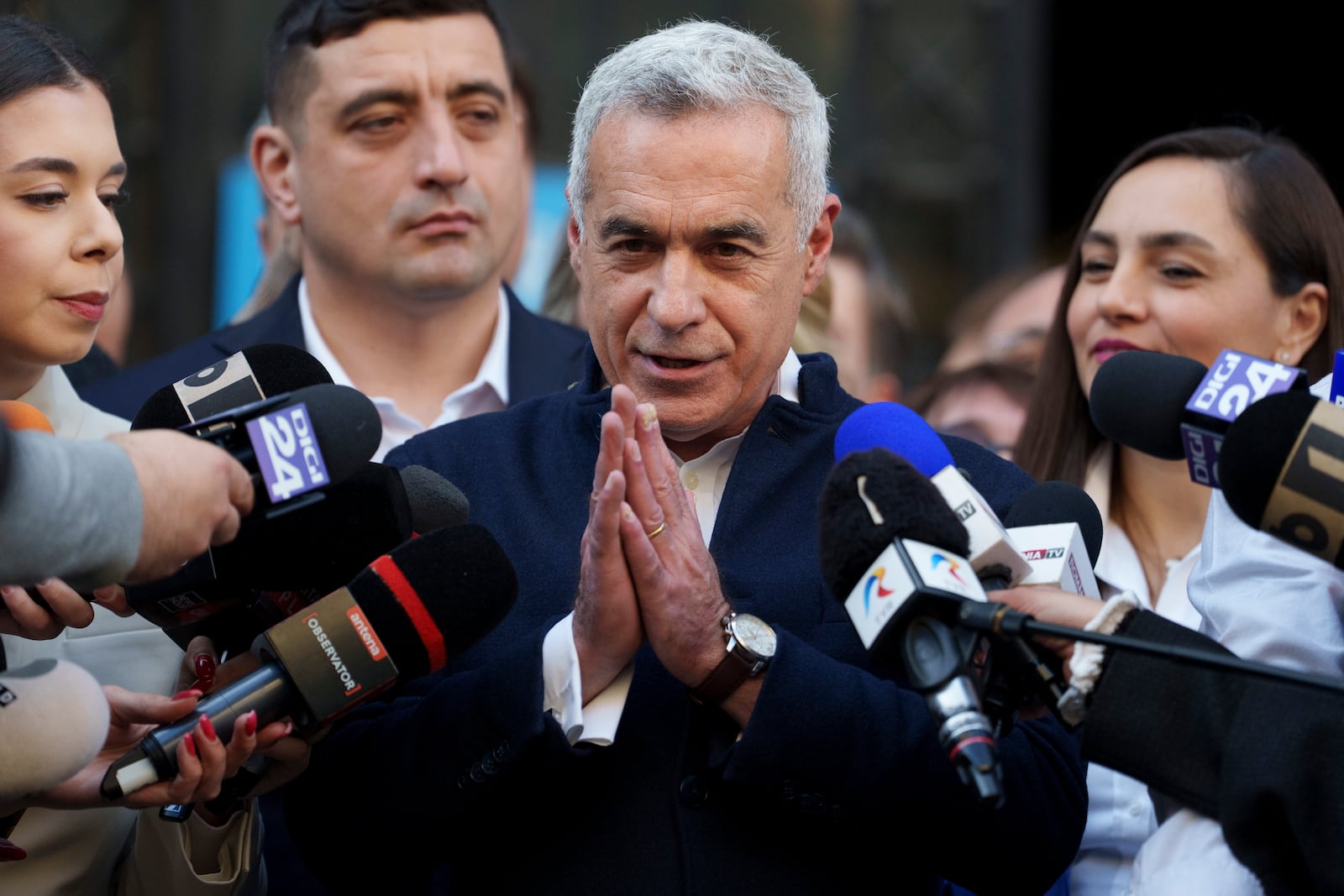 Calin Georgescu, the winner of the first round of presidential elections, later annulled by the Constitutional Court, speaks to media after registering his new bid for the country's presidency outside Romania's Electoral Authority, in Bucharest, Romania, Friday, March 7, 2025. (AP Photo/Andreea Alexandru)