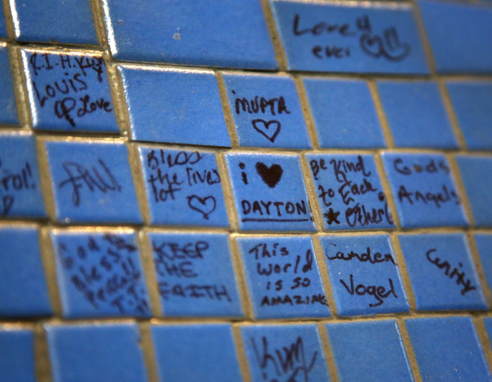 '9 Doves,' a mosaic mural created by the community to honor the nine people killed in the Oregon District mass shooting last year, was hung Tuesday, Aug. 3 in the lobby of Dayton's City Hall. Many people wrote messages on the porcelain pieces. LISA POWELL / STAFF