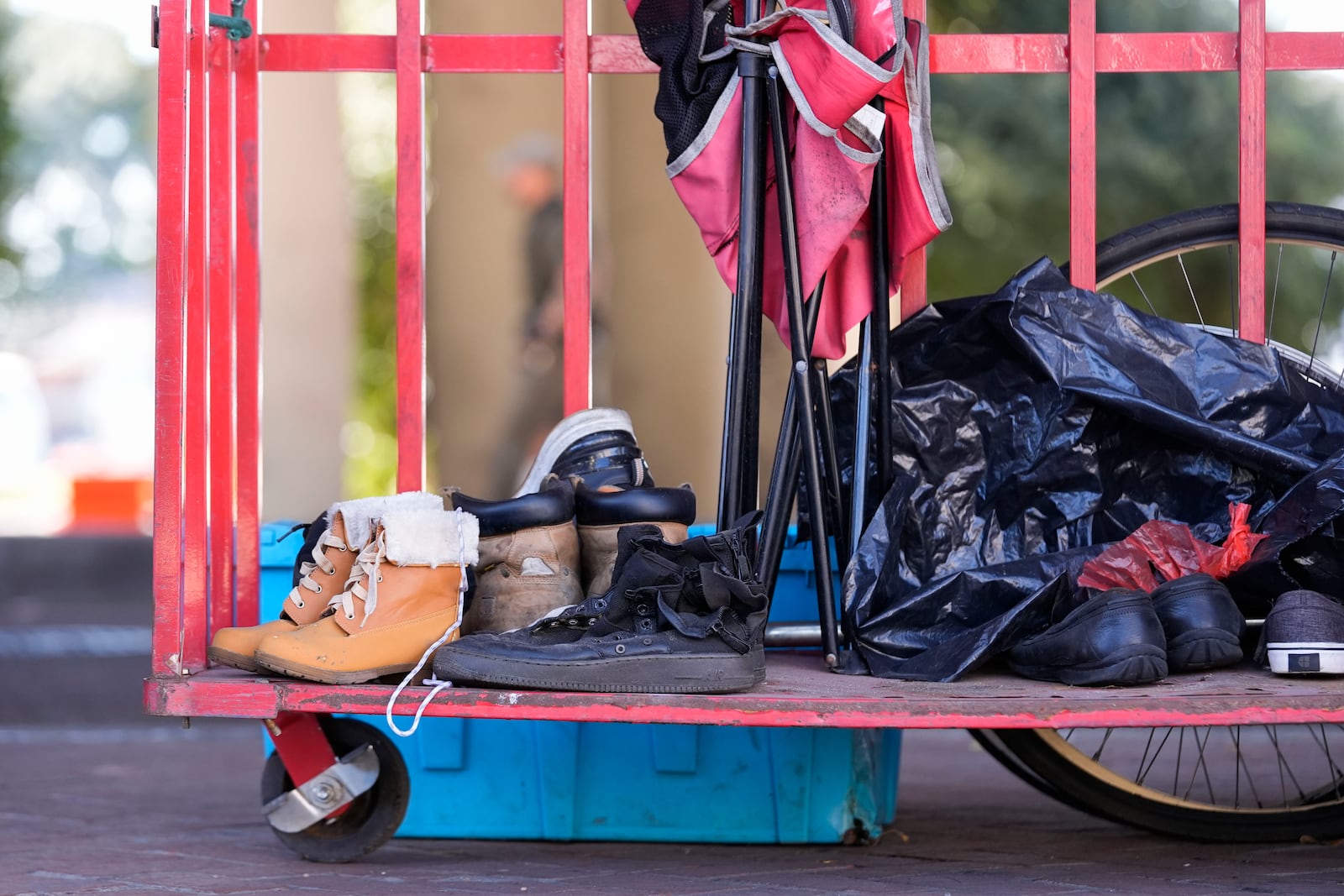 Possessions sit on a cart as Louisiana State police give instructions to people living in a homeless encampment to move to a different pre-designated location as they perform a sweep in advance of a Taylor Swift concert in New Orleans, Wednesday, Oct. 23, 2024. (AP Photo/Gerald Herbert)