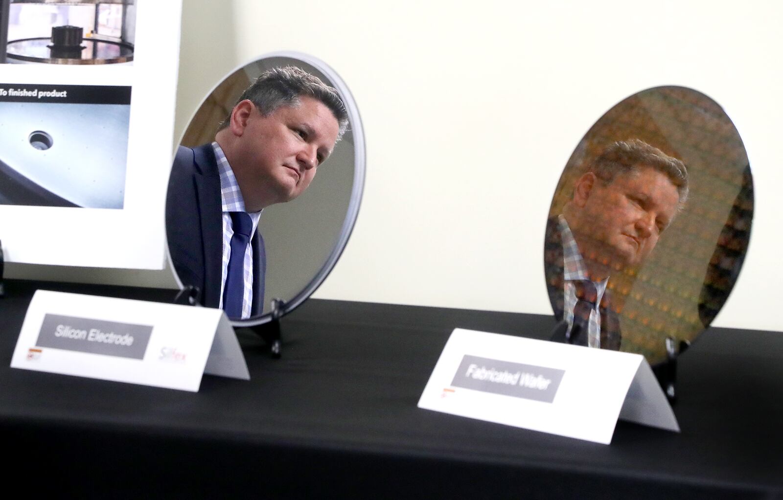 Rob Skrobak, general manager at Silfex, Incorporated, is reflected in a silicon electrode and a fabricated wafer as he listens to Senator Sherrod Brown Wednesday, Oct. 5, 2022. The senator was visiting Silfex to discuss how the recently passed CHIPS Act will support Ohio manufacturers. Silfex produces silicon electrodes and wafers that are used by semiconductor manufacturers to make microchips. BILL LACKEY/STAFF