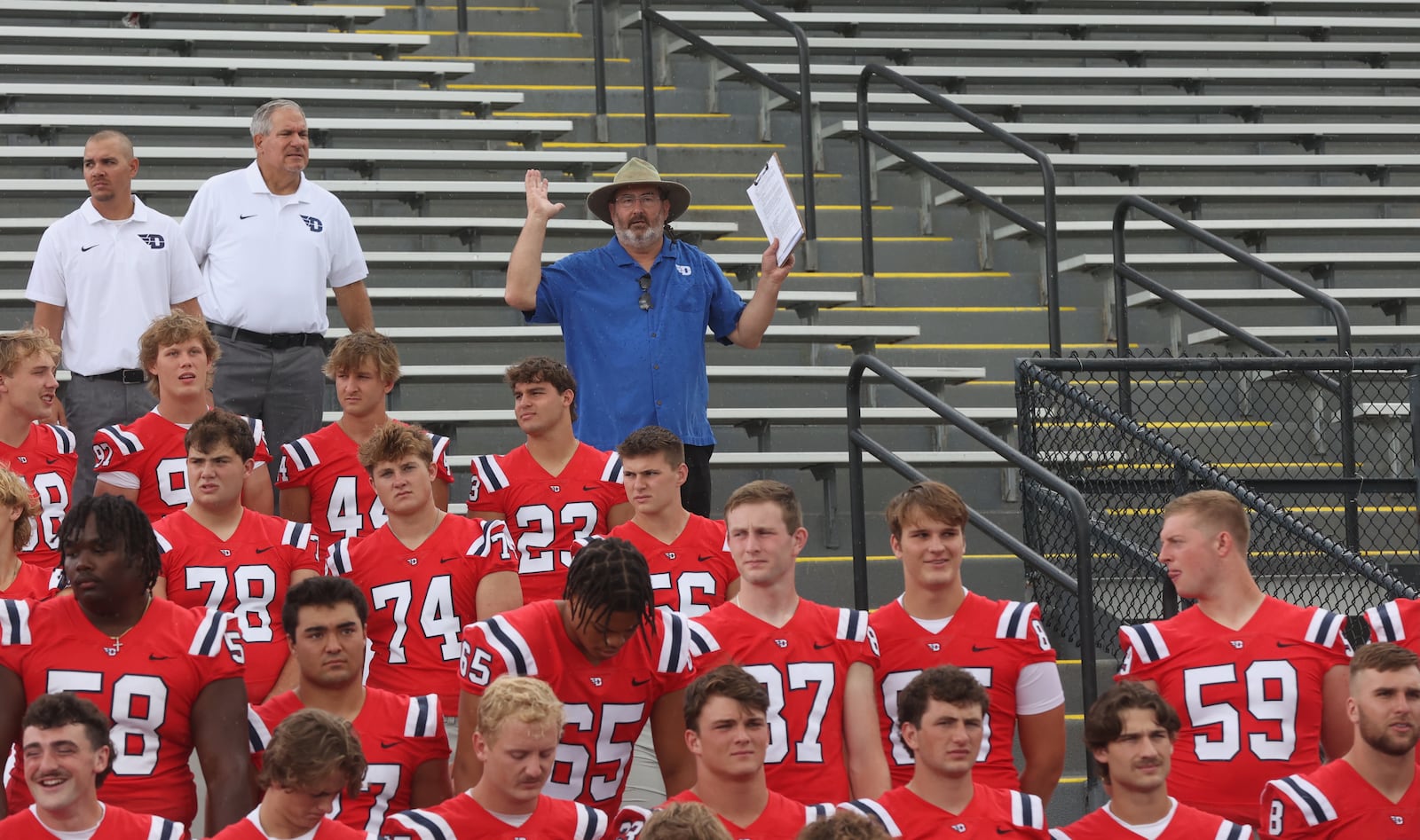 UD's Doug Hauschild directs the team photo shoot during Dayton football media day on Sunday, Aug. 18, 2024, at Welcome Stadium. David Jablonski/Staff