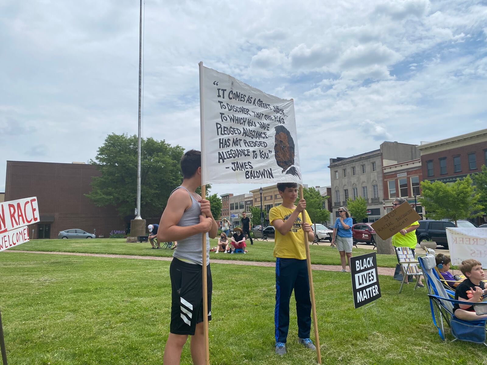 Protestors stand on the Greene County Courthouse lawn on Saturday, May 22. The quote on the sign is from James Baldwin. Eileen McClory / Staff