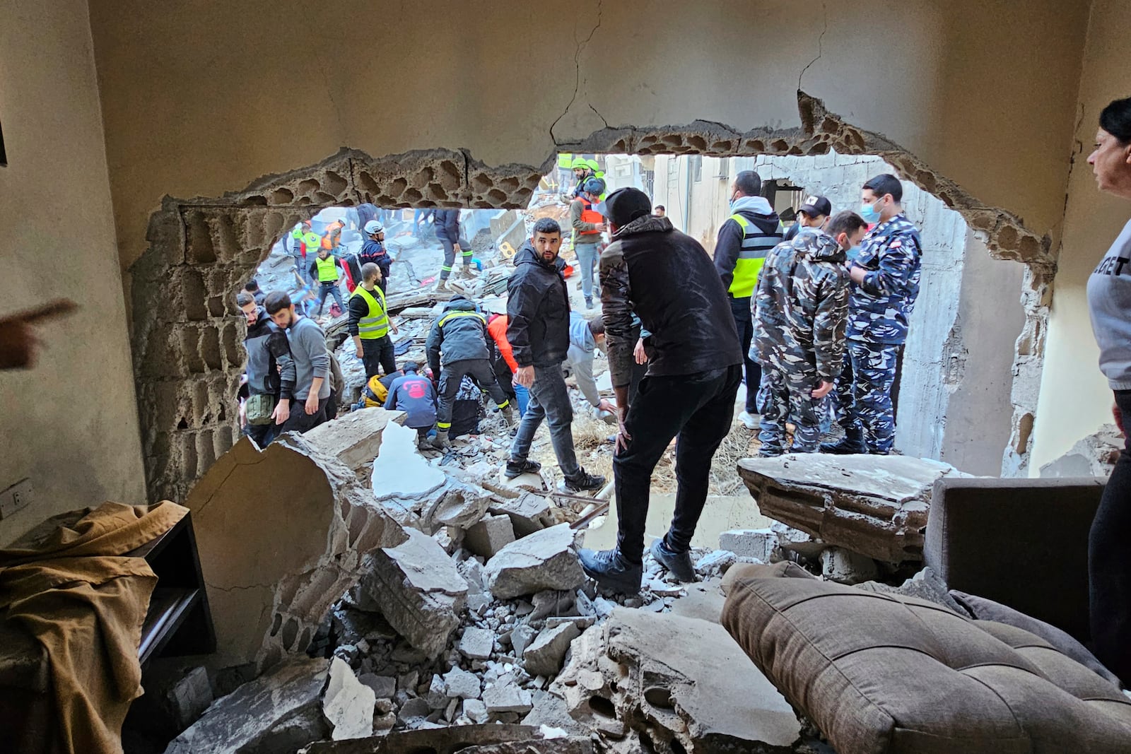 Rescuers and residents search for victims at the site of an Israeli airstrike that targeted a building in Beirut, Lebanon, Tuesday, Nov. 26, 2024. (AP Photo/Hassan Ammar)