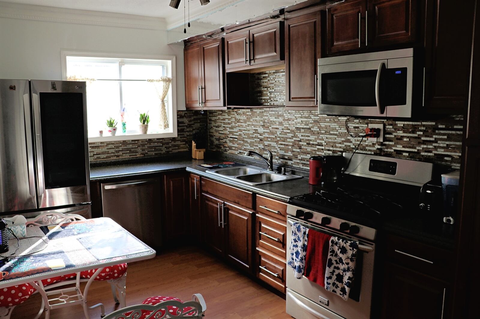 The kitchen has been updated with wood-laminate flooring and stainless-steel appliances. 