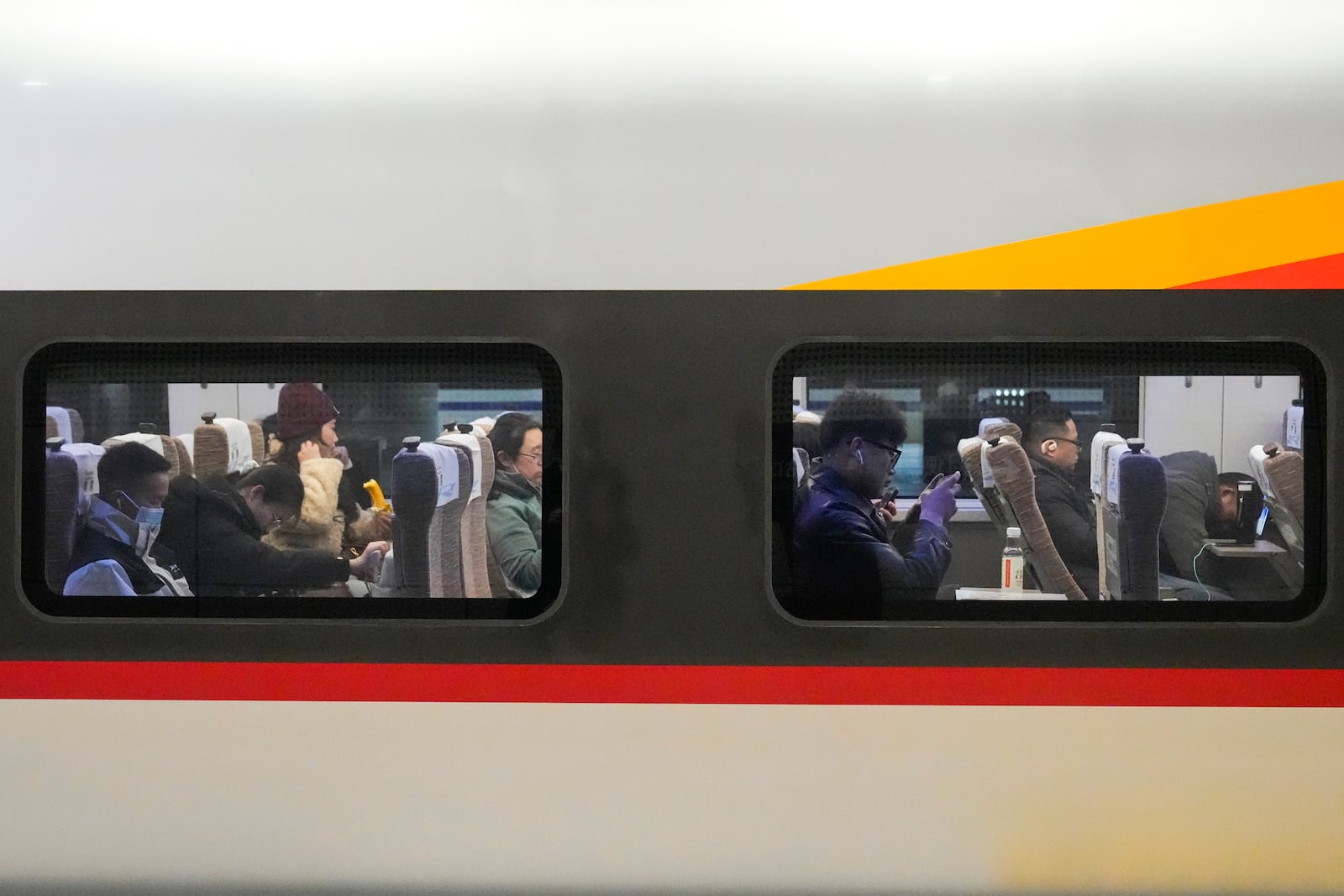 Travelers wait inside a bullet train at the Beijing West Railway Station ahead of the Lunar New Year in Beijing on Friday, Jan. 24, 2025. (AP Photo/Aaron Favila)