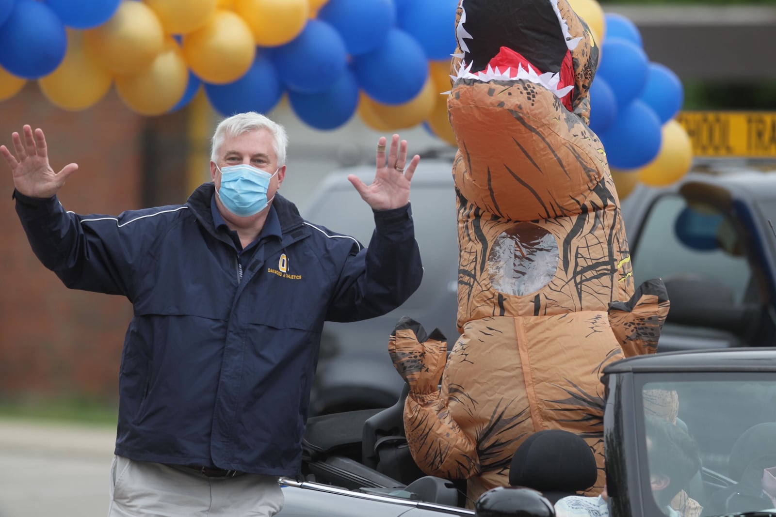 Oakwood High School Principal Paul Waller participates in a cap and gown drive-thru celebration behind the high school in May 2020 during COVID shutdowns. Seniors were encouraged to decorate their cars while teachers handed out caps, gowns and diplomas. JIM NOELKER/STAFF