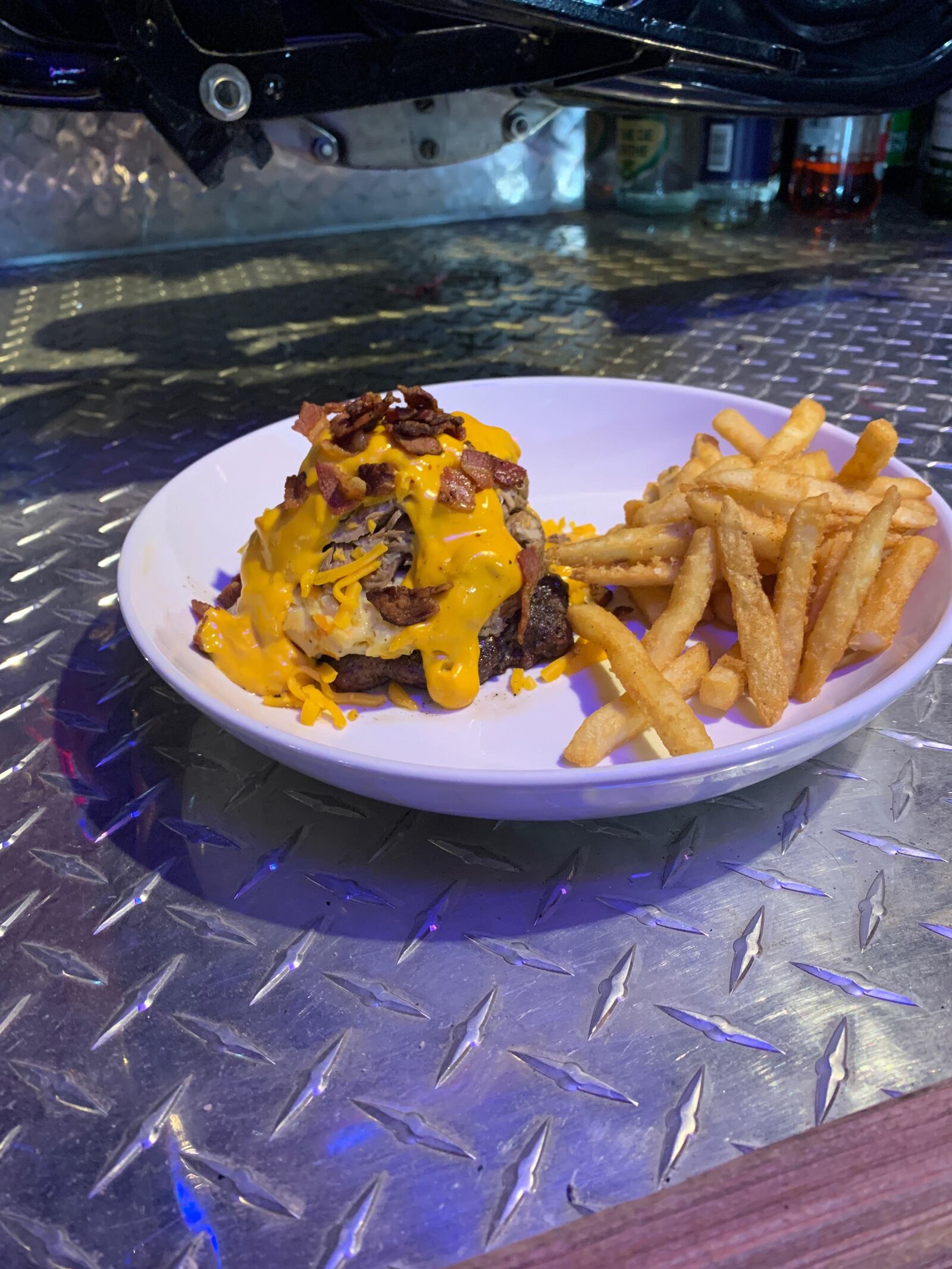 Rip Rap Roadhouse's Cheesy Tater Burger features a 1/2 lb. black Angus choice beef burger, covered with 1/4 lb. smoked pulled pork, a scoop of cheesy potatoes instead of a bun, covered in cheese sauce, and sprinkled with bacon bits. CONTRIBUTED