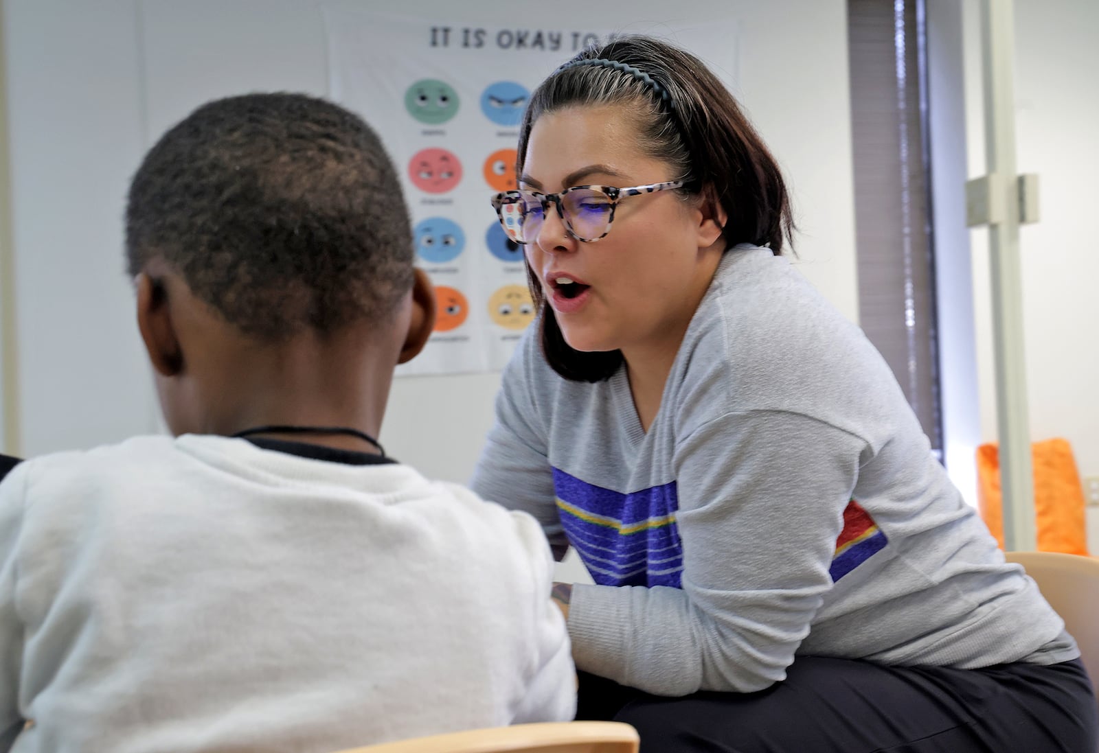 Allie Kucinski, a mental health care provider at Kids Thrive, works with a child about their feelings. BILL LACKEY/STAFF