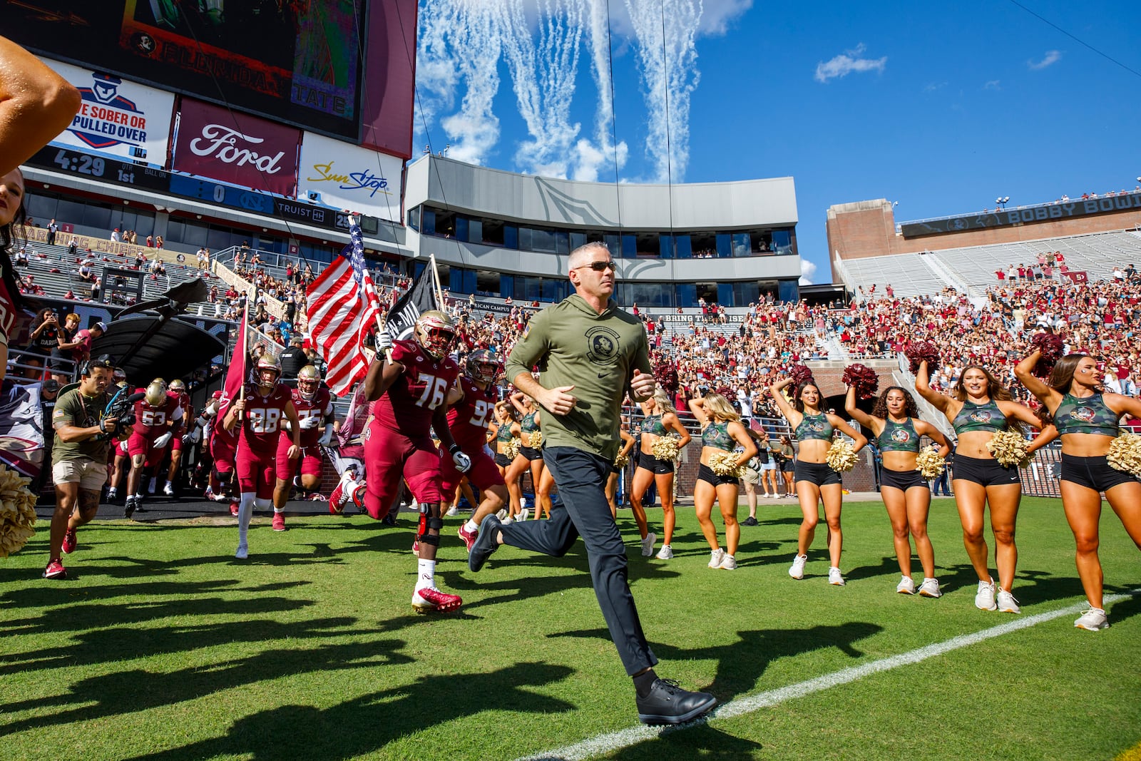 Florida State head coach Mike Norvell, center, leads his team onto the field before an NCAA college football game against North Carolina, Saturday, Nov. 2, 2024, in Tallahassee, Fla. (AP Photo/Colin Hackley)