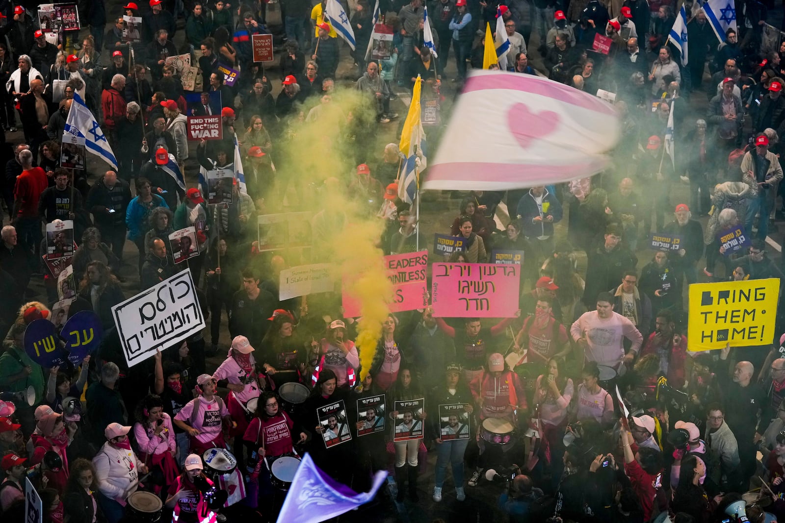 Demonstrators hold signs during a protest calling for the immediate release of the hostages held in the Gaza Strip by Hamas militant group, in Tel Aviv, Israel, Saturday, Jan. 11, 2025. (AP Photo/Ariel Schalit)