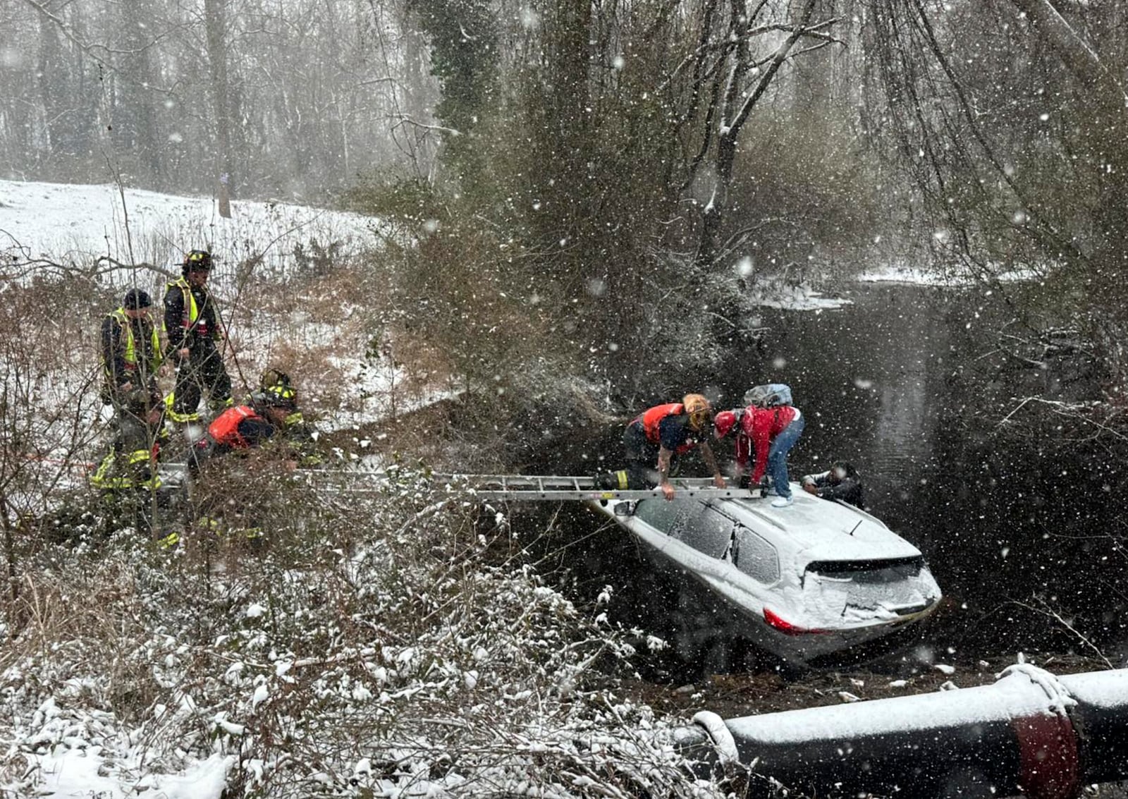 This image provided by the City of Suffolk Department of Fire & Rescue shows emergency workers rescuing two people from an SUV that crashed into water, Wednesday, Feb. 19, 2025 in Suffolk, Va. (City of Suffolk Department of Fire & Rescue via AP)