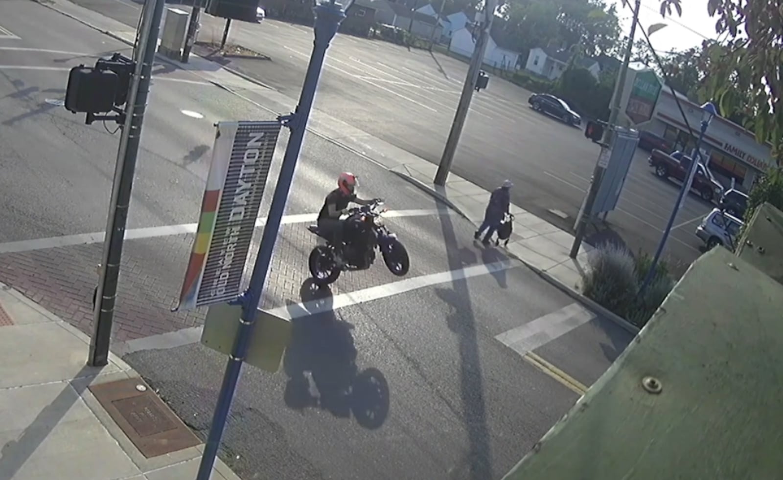 A motorcycle rider does a wheelie about 20 feet from a pedestrian using a walker to cross a street in Old North Dayton this week. CONTRIBUTED PHOTO