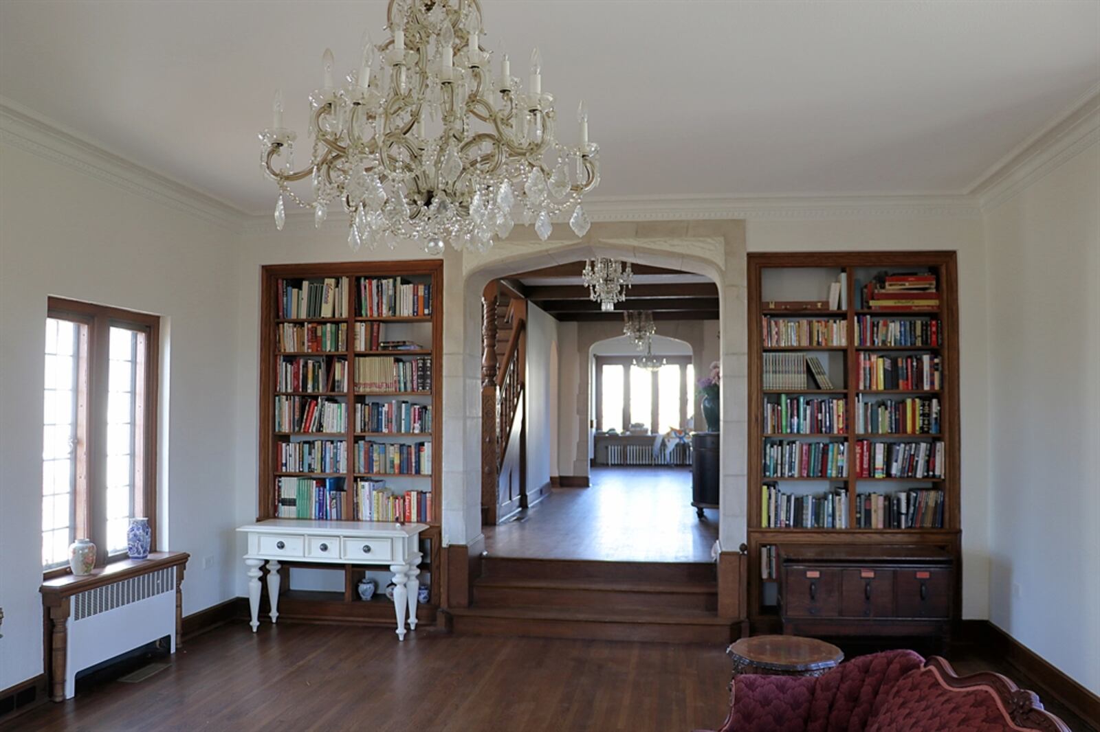 In the great room, built-in bookcases flank the short staircase threshold.