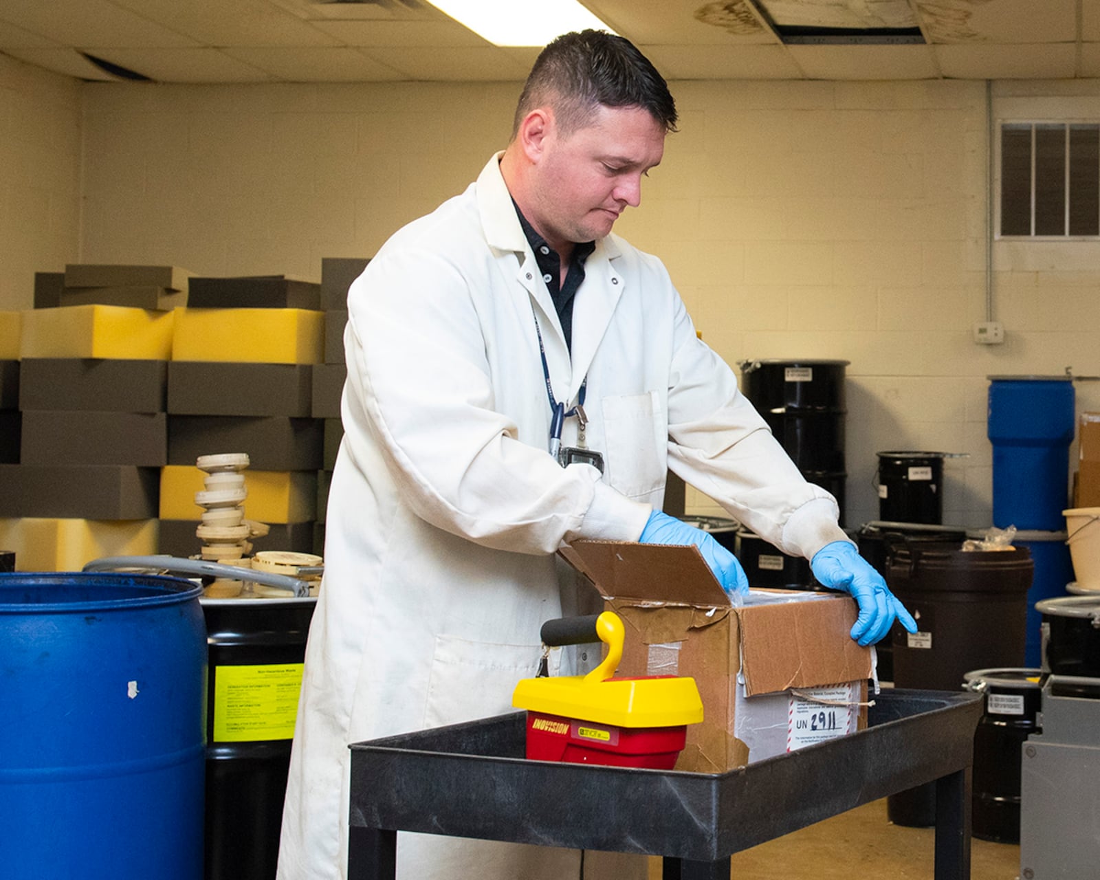 Seth Walton opens a box containing lensatic compasses shipped to the Air Force Radioactive Recycling and Disposal facility Dec. 1 at Wright-Patterson Air Force Base. The compasses contain tritium, which will be removed, renewed and replaced back in their housings for use again through a series of contracts with AFRRAD, the compass manufacturer and other agencies. U.S. AIR FORCE PHOTO/JAIMA FOGG