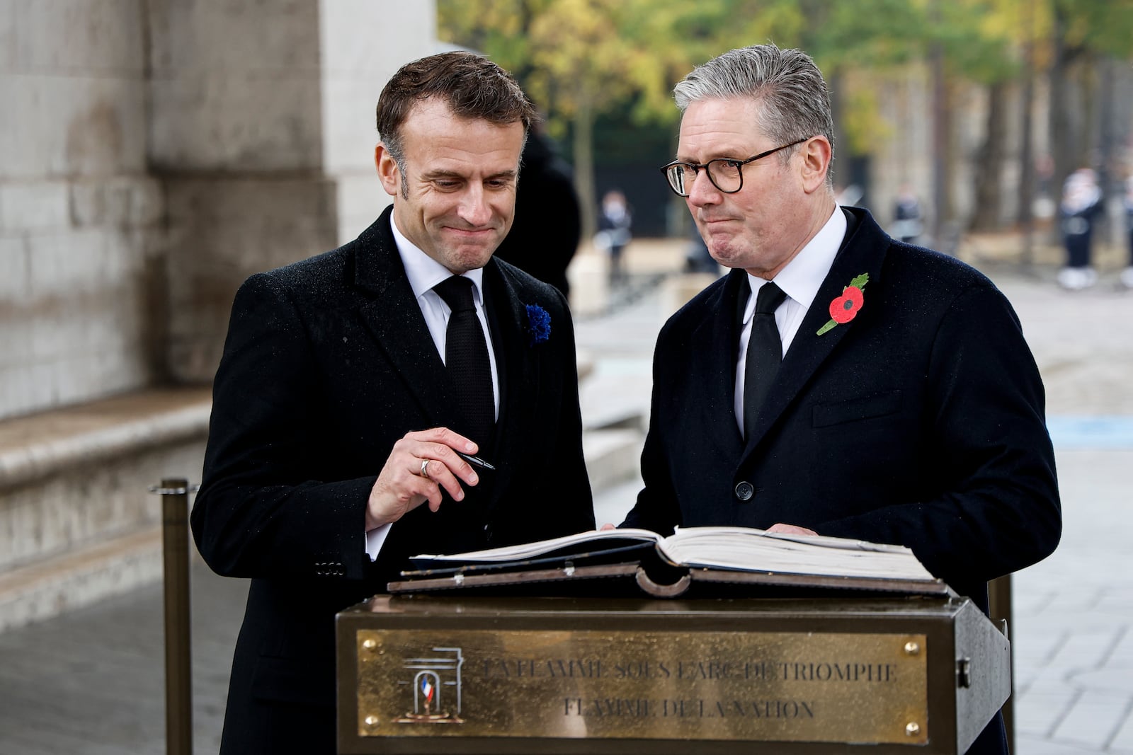 French President Emmanuel Macron, left, and Britain's Prime Minister Keir Starmer sign the Golden Book of the Unknown Soldier during commemorations marking the 106th anniversary of the November 11, 1918, Armistice, ending World War I, in Paris, Monday, Nov. 11, 2024. ( Ludovic Marin, Pool via AP)