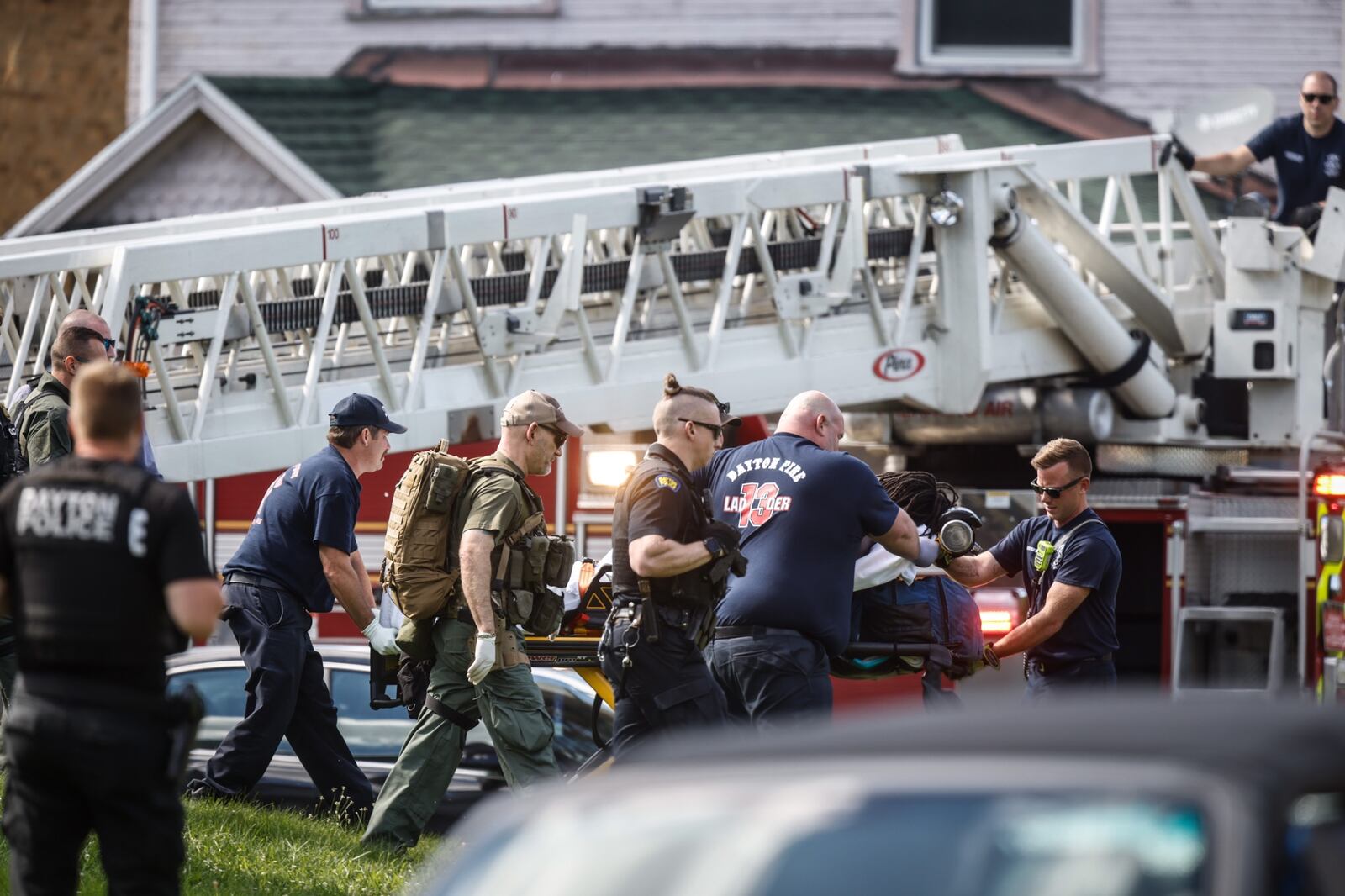 A man climbed down a Dayton Fire Department ladder after he had been on the roof of a Superior Avenue house for about five hours. Dayton police said the man fled into a home and eventually got on the roof after police arrived to take him into custody on felony warrants out of Minnesota. JIM NOELKER/STAFF