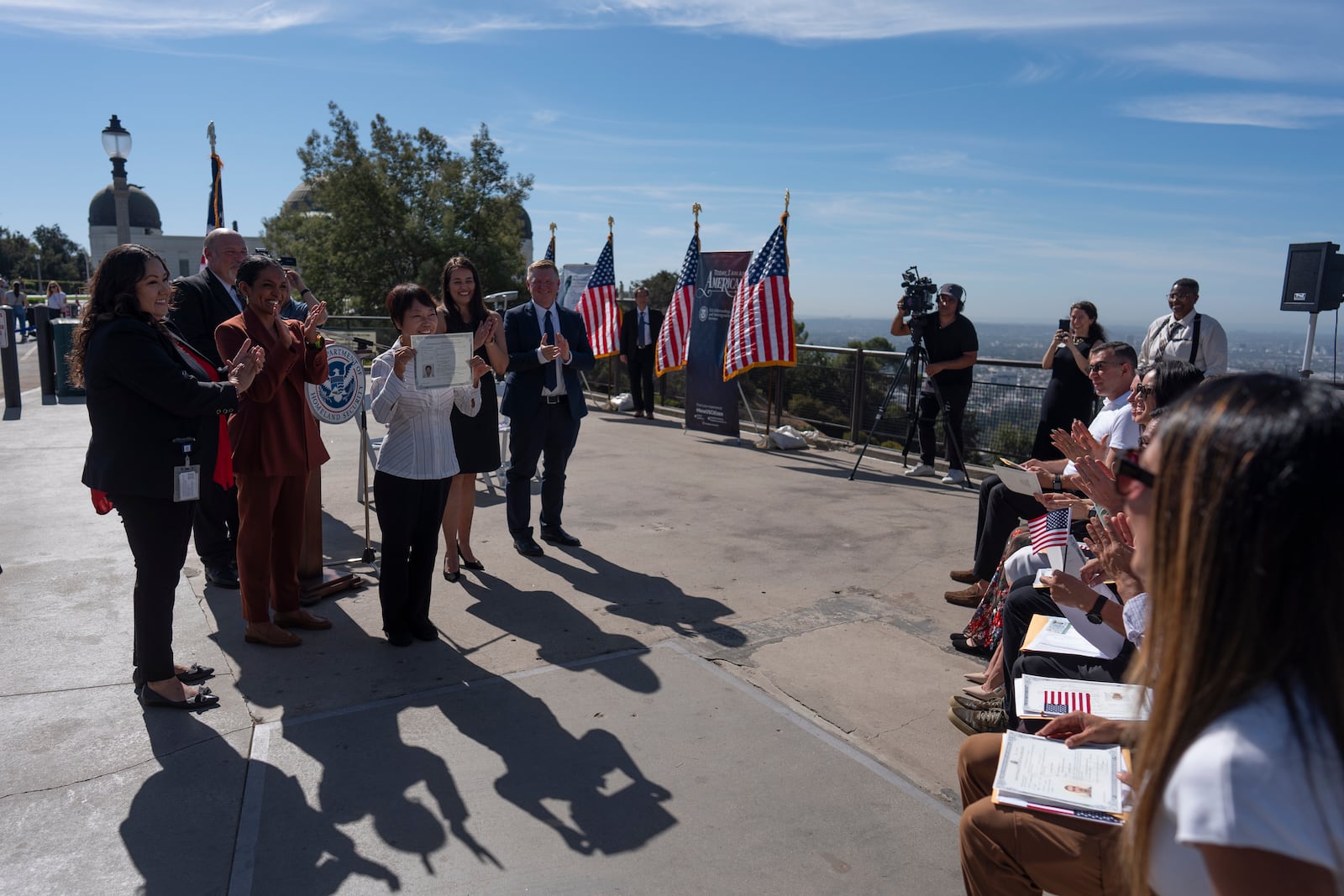 Shuk Ching Chan holds up her certificate of citizenship during a naturalization ceremony at Griffith Observatory in Los Angeles, Monday, Oct. 21, 2024. (AP Photo/Jae C. Hong)