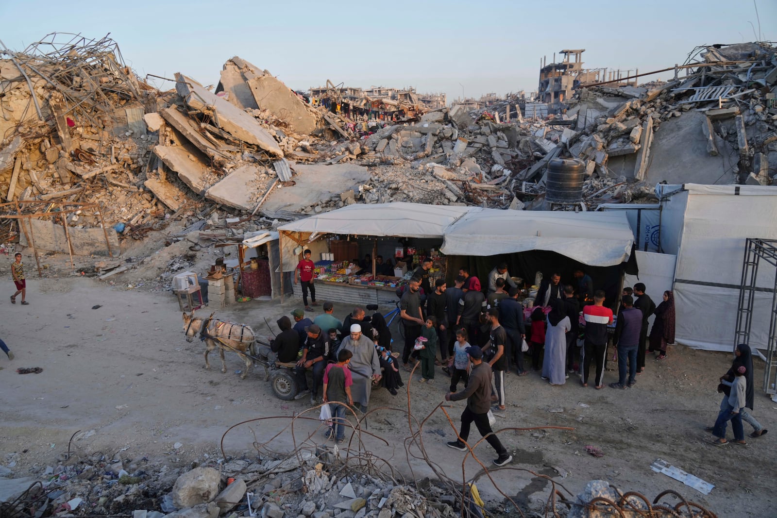 Palestinians walk amid the rubble of destroyed homes and buildings in Jabaliya, northern Gaza Strip on Friday, March 14, 2025. (AP Photo/Jehad Alshrafi)