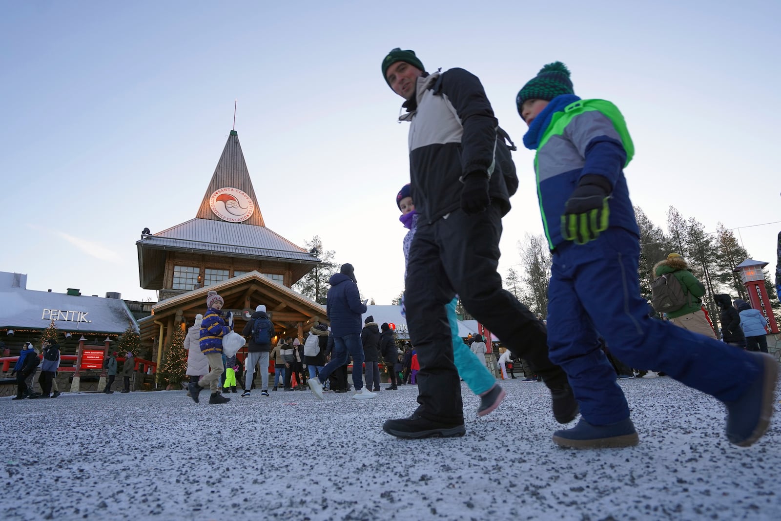 Tourists visit Santa Claus Village, a winter-themed amusement park perched on the edge of the Arctic Circle, in Rovaniemi, Finland, Wednesday, Dec. 4, 2024. (AP Photo/James Brooks)