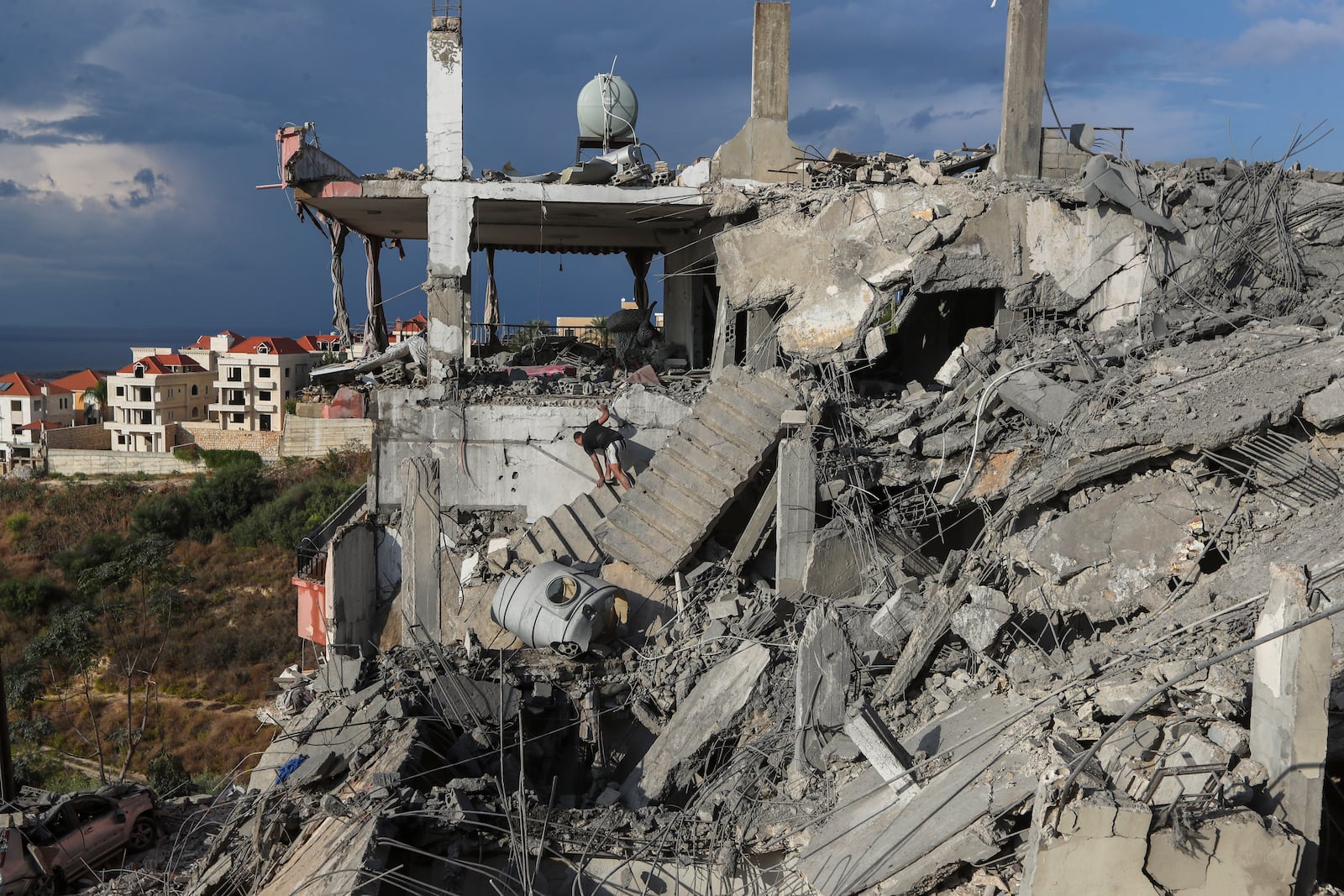 A man inspects a destroyed building hit in an Israeli airstrike, in Ghaziyeh town, south Lebanon, Sunday, Nov. 3, 2024. (AP Photo/Mohammed Zaatari)