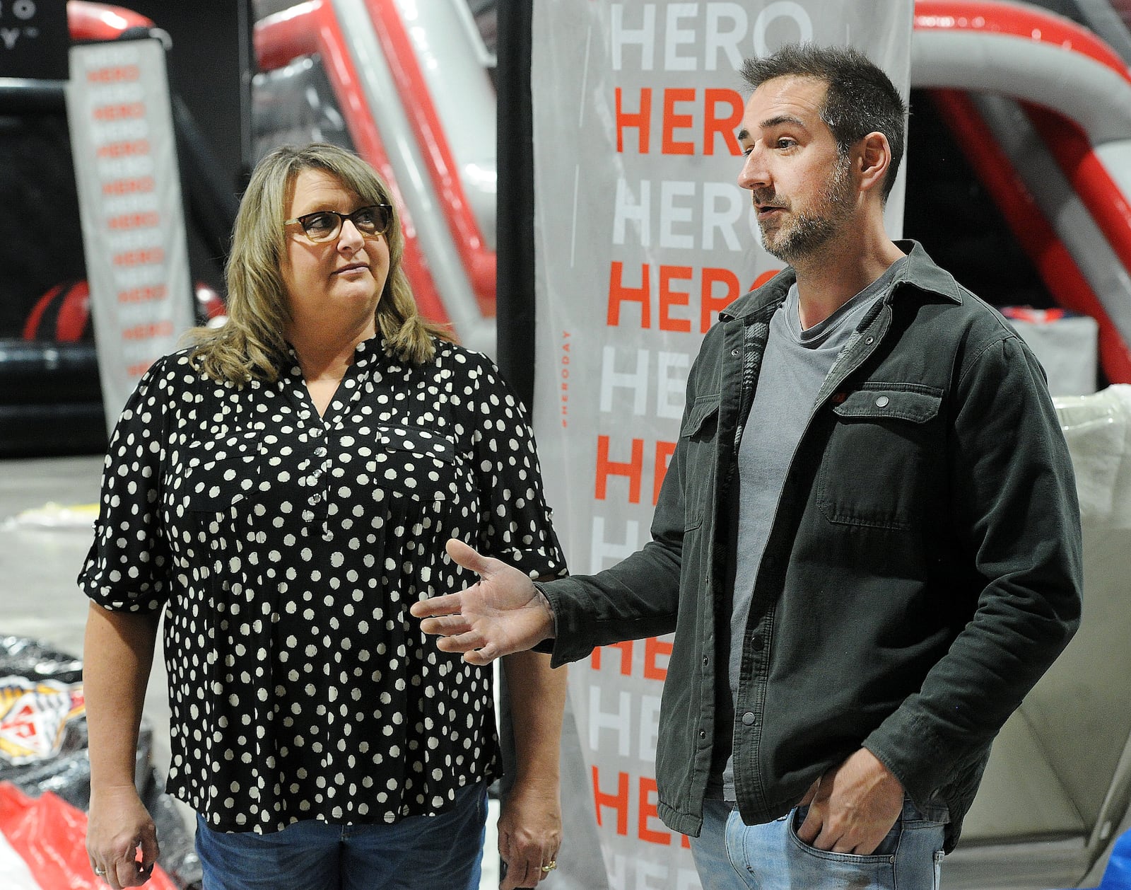 Helga Leep, onsite manager for the Piqua Center, (left) and Brad Gossard, owner of the Hero Day Inflatable Theme Park, (right) talk about features of the Hero Day, an amusement park opening in the Piqua Center in March.  The Piqua Center, previously known as the Miami Valley Centre Mall, is planning new experiences for customers in 2024 after the property was acquired by new owners last year. One new business is Hero Day, one of the world's largest indoor action parks for family entertainment and birthday parties. MARSHALL GORBY\STAFF