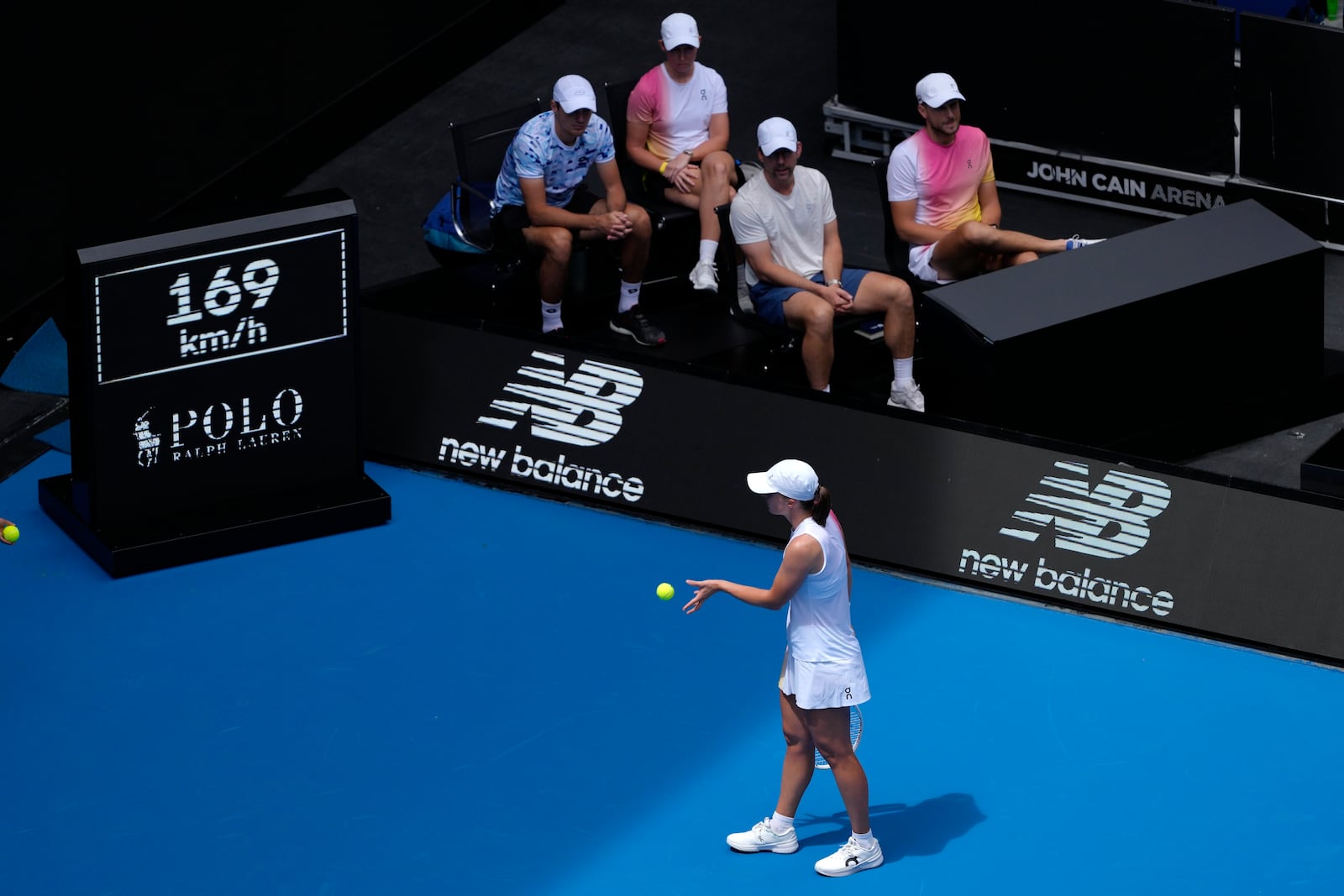 Iga Swiatek of Poland walks past her coaches as she prepares to serve to Katerina Siniakova of the Czech Republic during their first round match at the Australian Open tennis championship in Melbourne, Australia, Monday, Jan. 13, 2025. (AP Photo/Ng Han Guan)