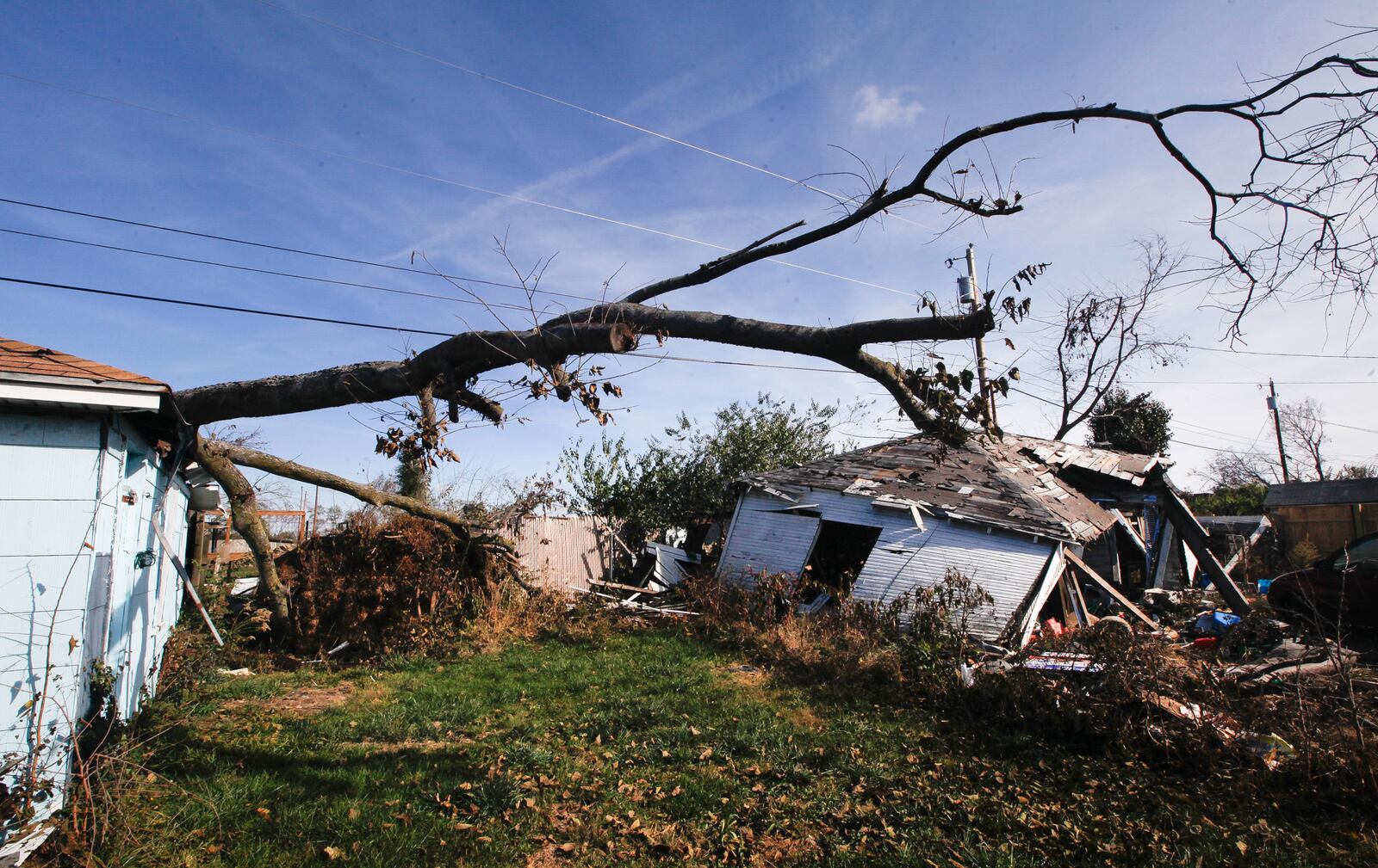 More than five months after the Memorial Day tornadoes, a tree remains atop a damaged garage behind a Macready Avenue home in Old North Dayton. CHRIS STEWART / STAFF