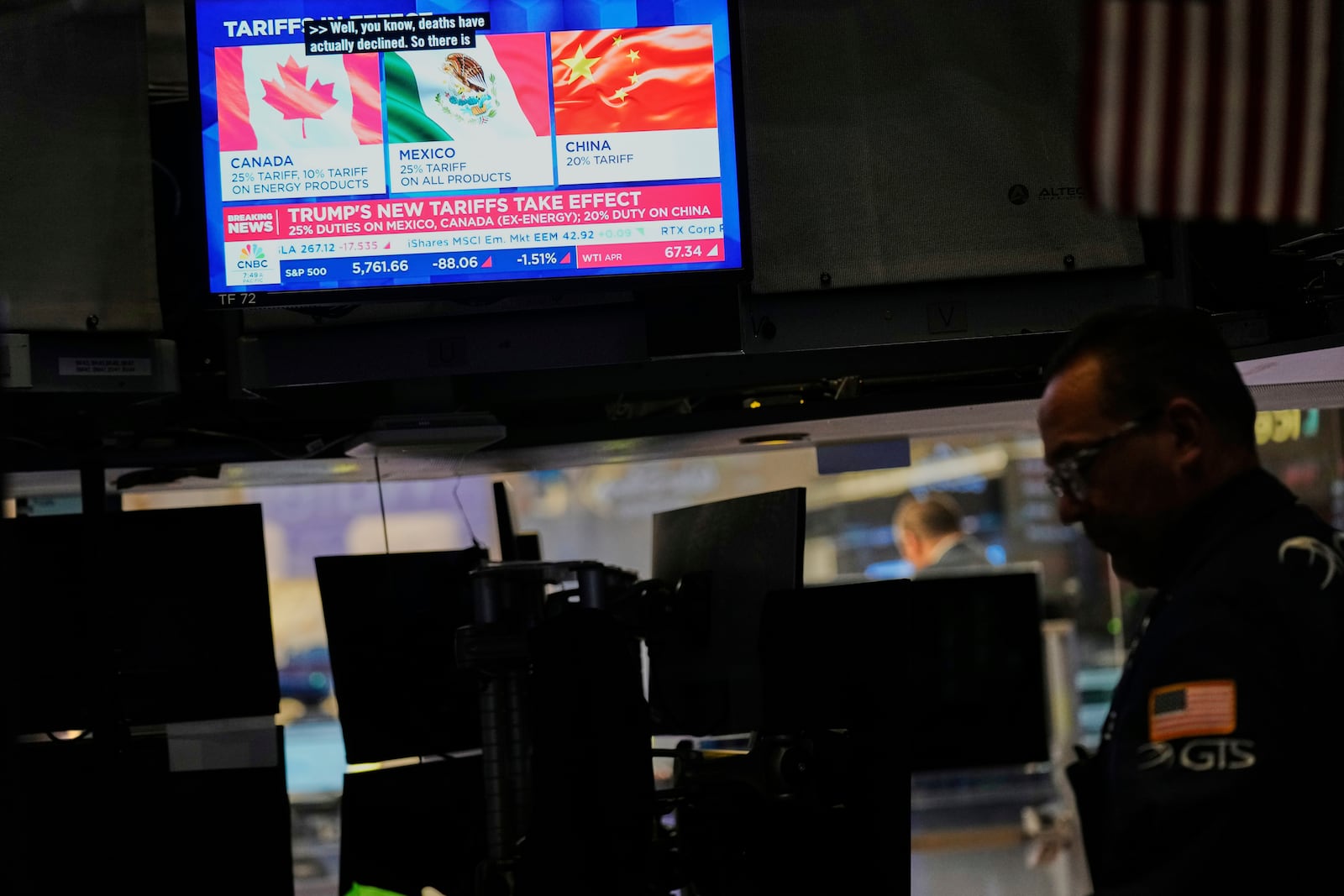 Financial news is displayed as Ppeople work on the floor at the New York Stock Exchange in New York, Tuesday, March 4, 2025. (AP Photo/Seth Wenig)