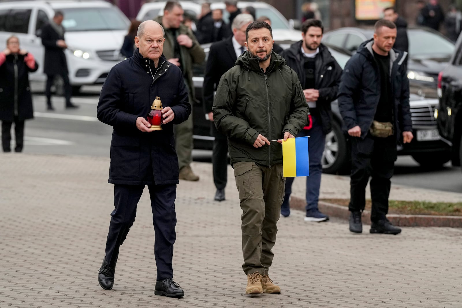 Ukraine's President Volodymyr Zelenskyy, right, and German Chancellor Olaf Scholz attend a ceremony of honoring fallen soldiers near the People's Memorial of National Memory in Kyiv, Ukraine, Monday, Dec.2, 2024. (AP Photo/Evgeniy Maloletka)