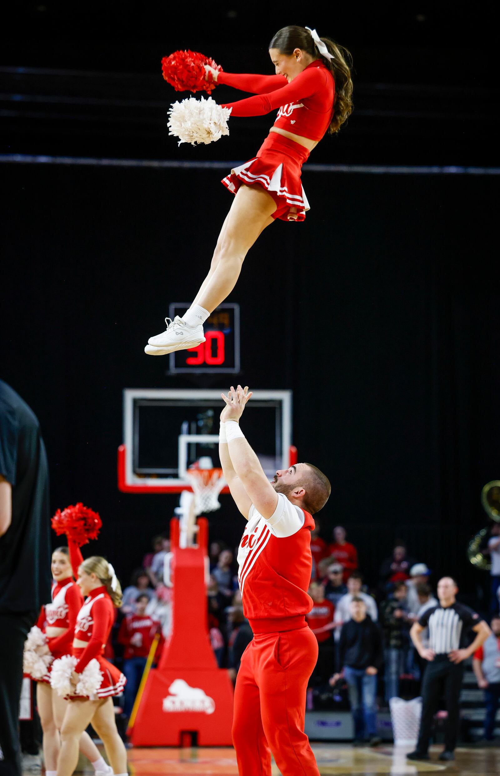 Miami University Braden Cowger catches teammate Sophia Knaier during the Miami Redhawks basketball game Friday, March 7, 2025 at Millett Hall in Oxford. The four male cheerleaders are also engineering majors at Miami. NICK GRAHAM/STAFF