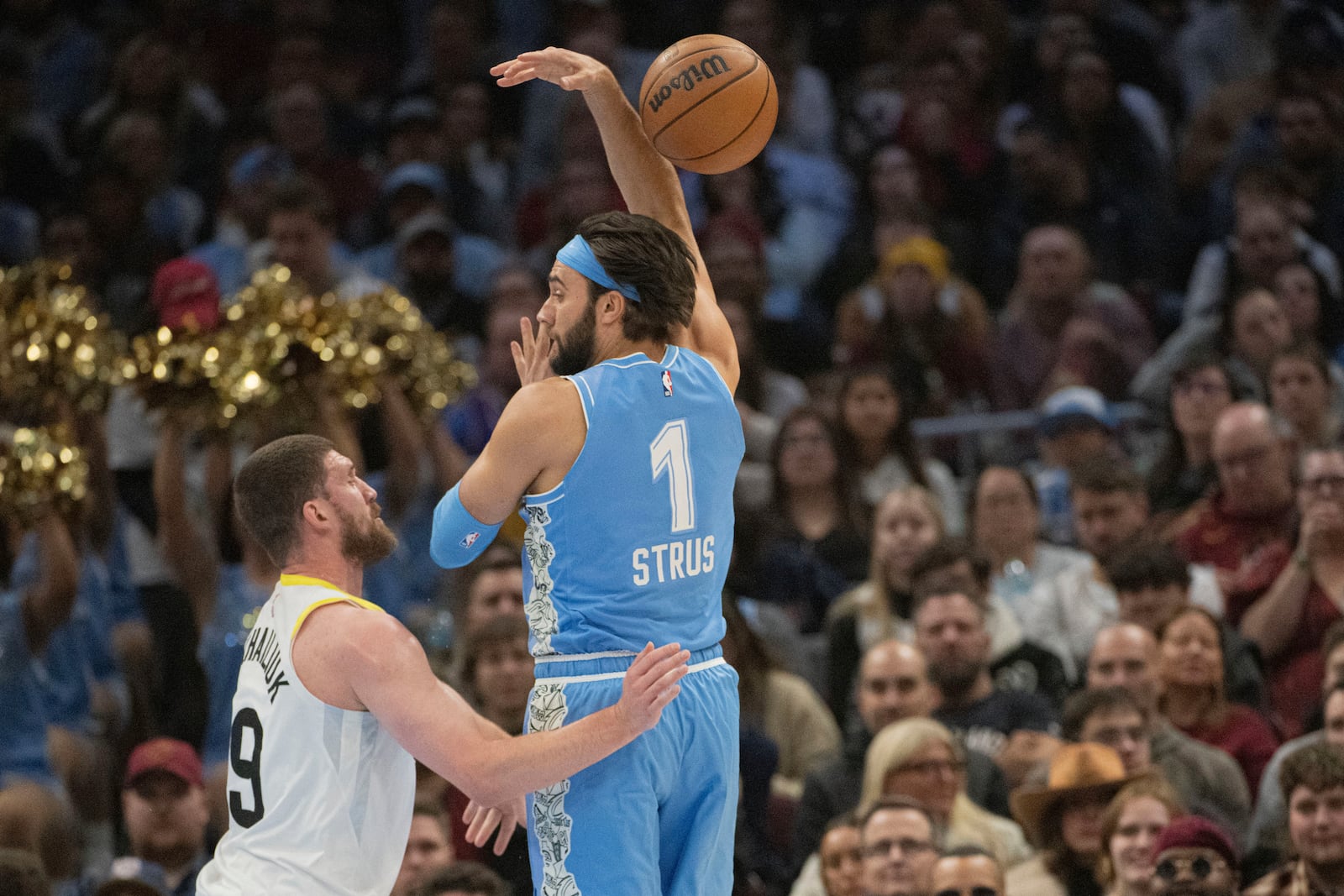 Utah Jazz's Svi Myhailiuk, left, defends as Cleveland Cavaliers' Max Strus (1) loses control of the ball during the first half of an NBA basketball game in Cleveland, Monday Dec. 23, 2024. (AP Photo/Phil Long)