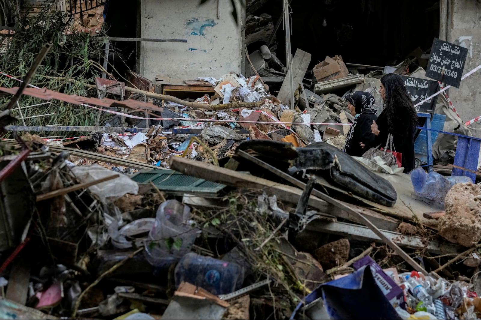 Women react as they pass through debris of a building hit on Monday evening by an Israeli airstrike in central Beirut, Lebanon, Tuesday, Nov. 19, 2024. (AP Photo/Bilal Hussein)