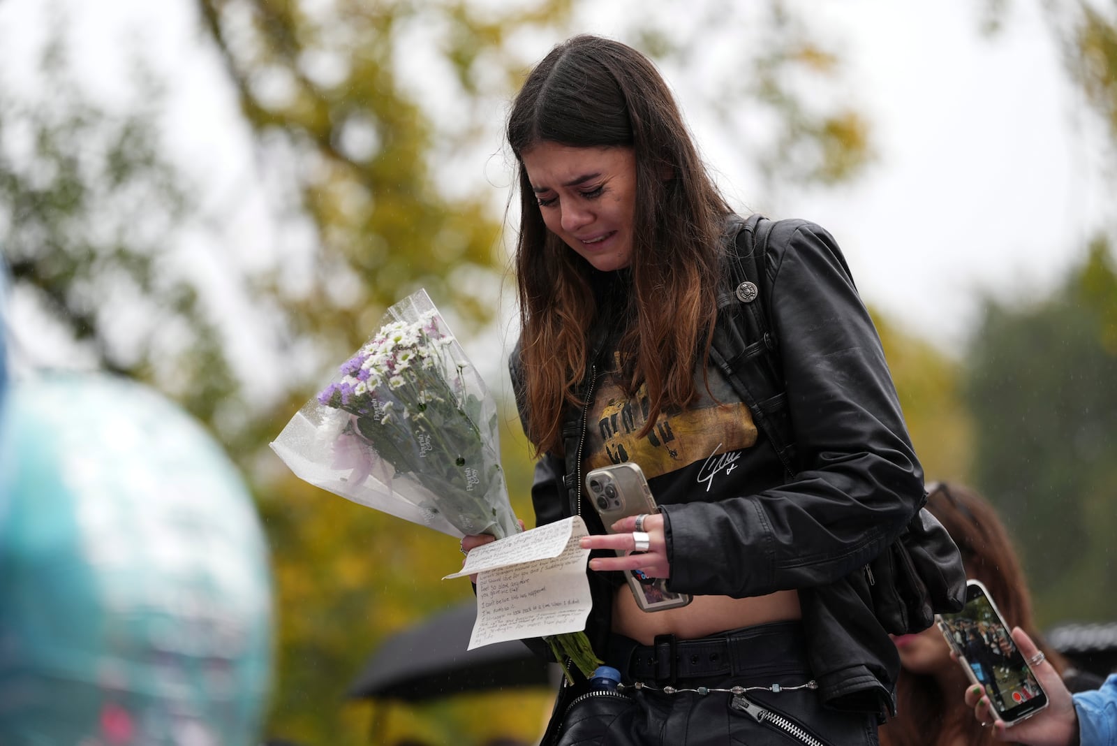 Fans react as they gather near the Peter Pan statue in Hyde Park, London to pay tribute to late British singer Liam Payne, former member of the British pop band One Direction, Sunday, Oct. 20, 2024. (Photo by Scott A Garfitt/Invision/AP)