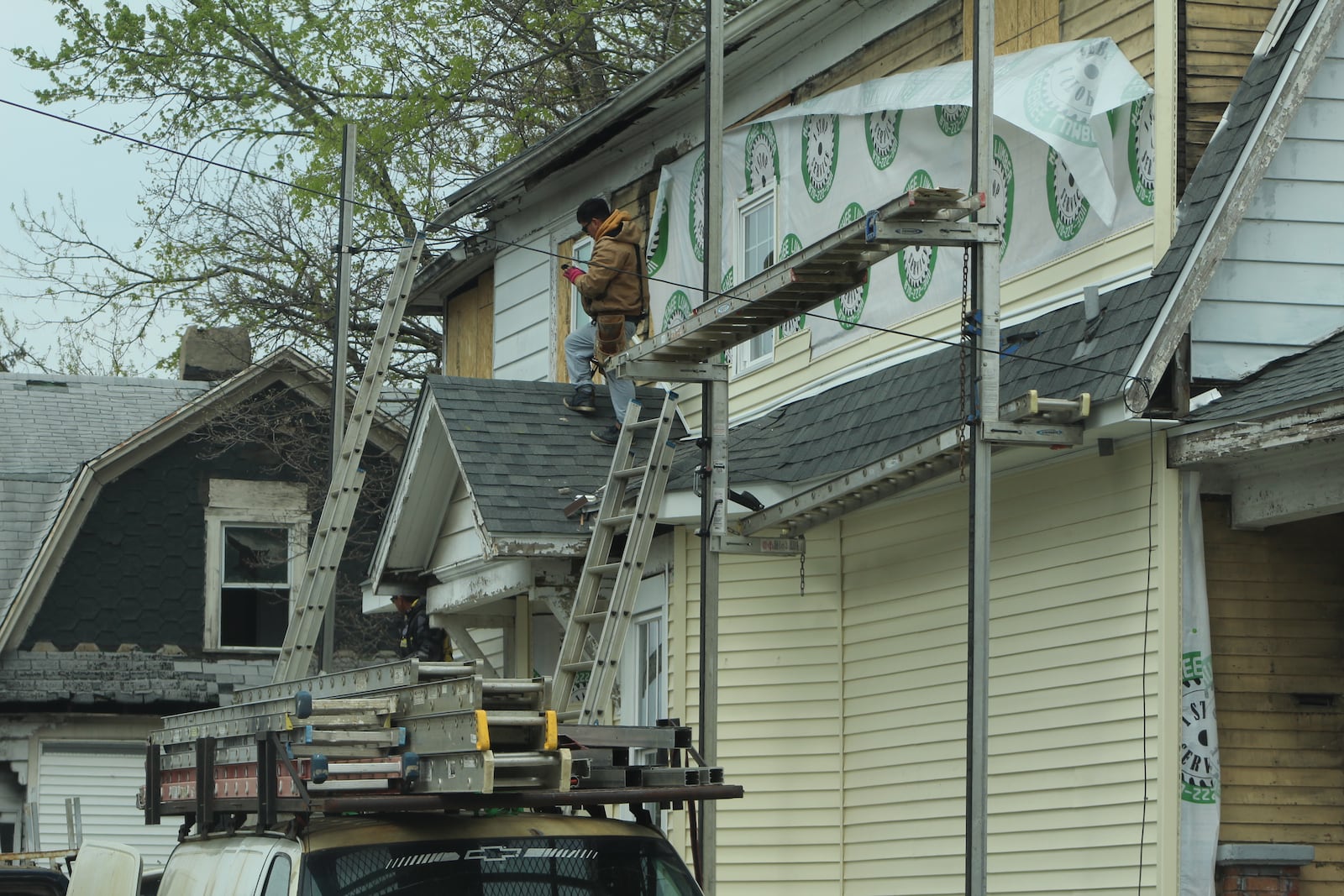 Crews work on a home in East Dayton. CORNELIUS FROLIK / STAFF