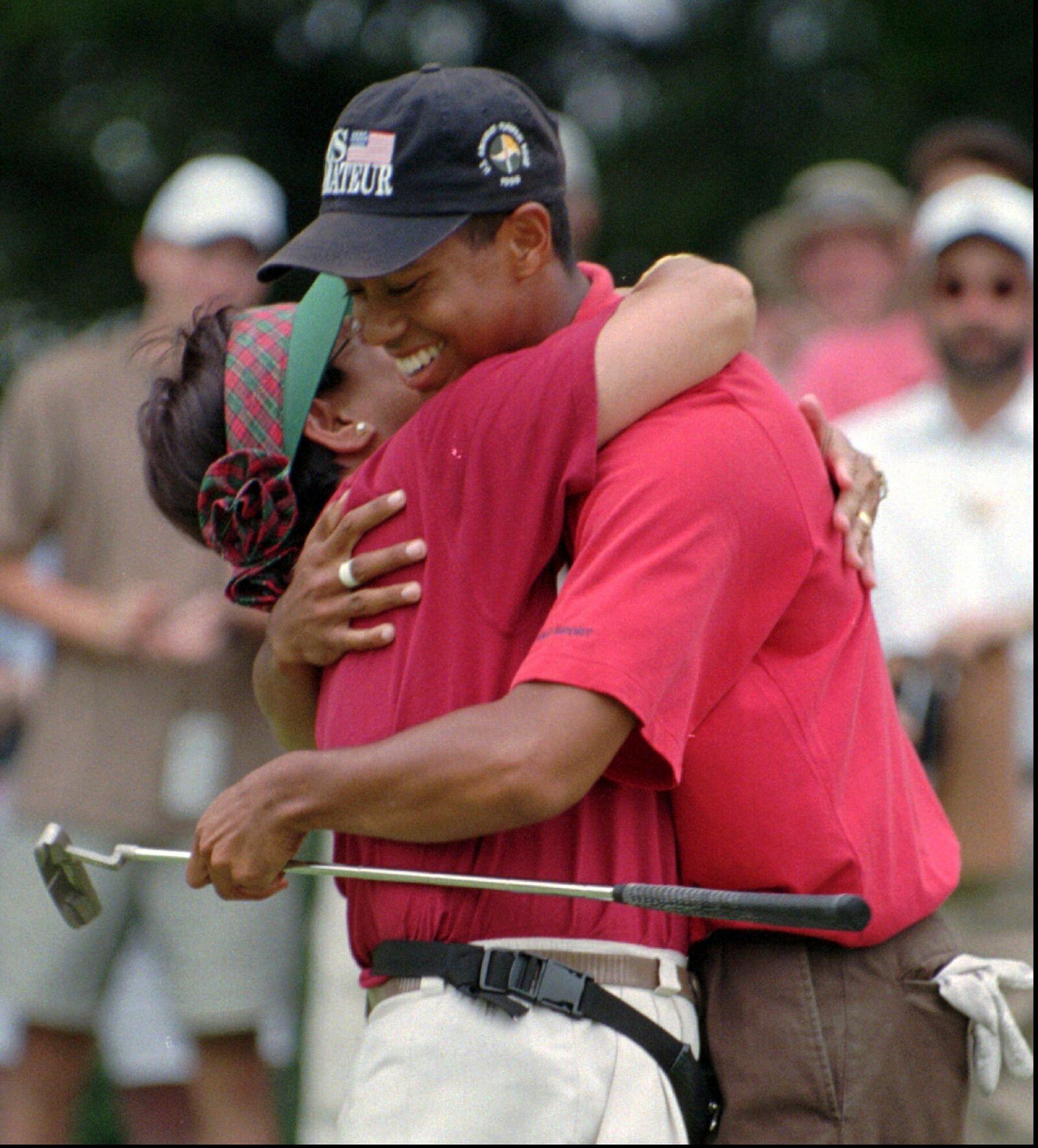 FILE - Tiger Woods is embraced by his mother, Kultida, after winning his third U.S. Amateur golf championship Sunday, Aug. 25, l996, at the Pumpkin Ridge Golf Club in North Plains, Ore. Woods defeated Steve Scott on the 38th hole.(AP Photo/Jack Smith, File)