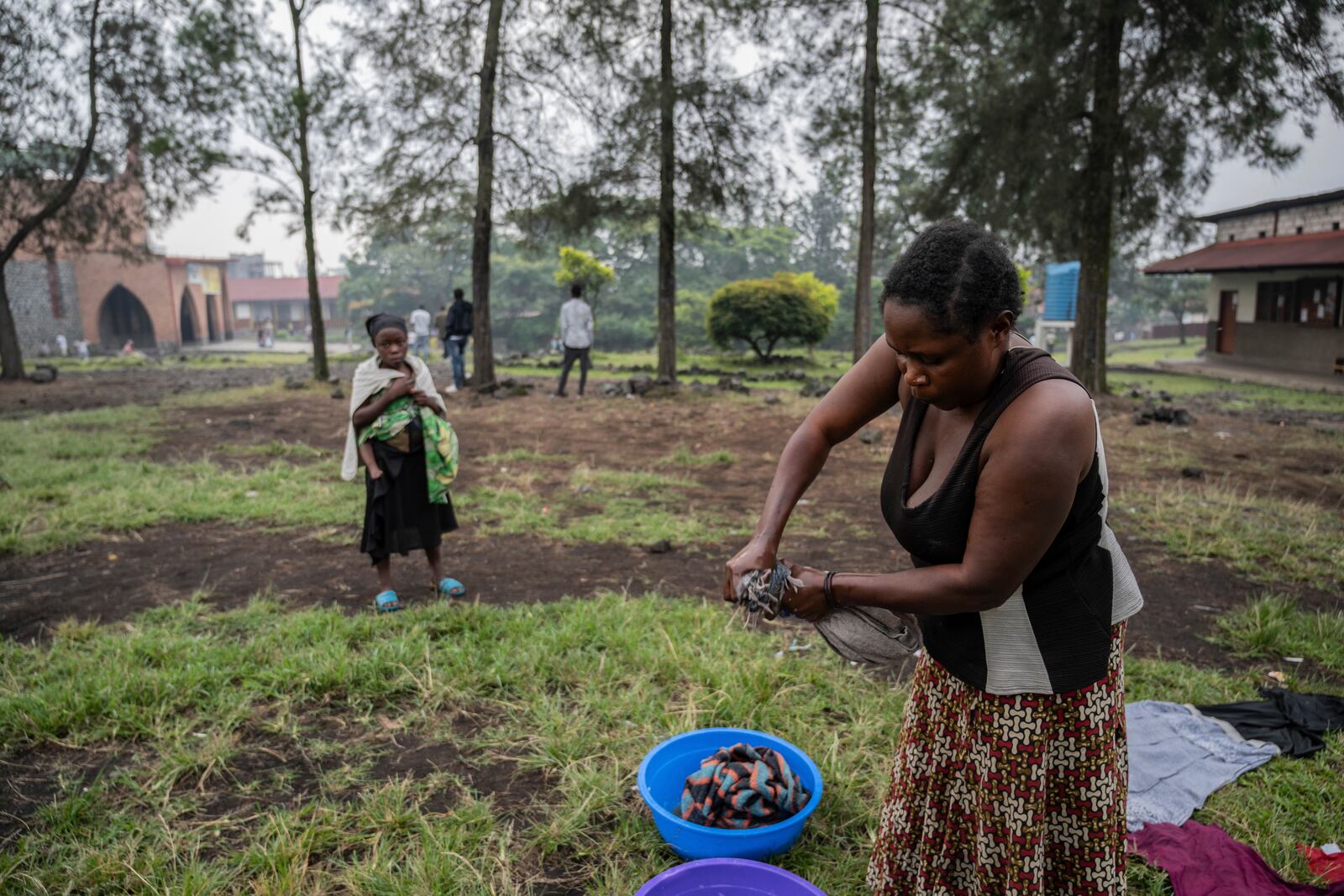 Zawadi Sifa, 35, mother of seven, who has been fleeing fighting from camp to camp, washes clothes in her latest displaced camp in Goma, Democratic Republic of the Congo, Thursday, Feb. 5, 2025.(AP Photo/Moses Sawasawa)