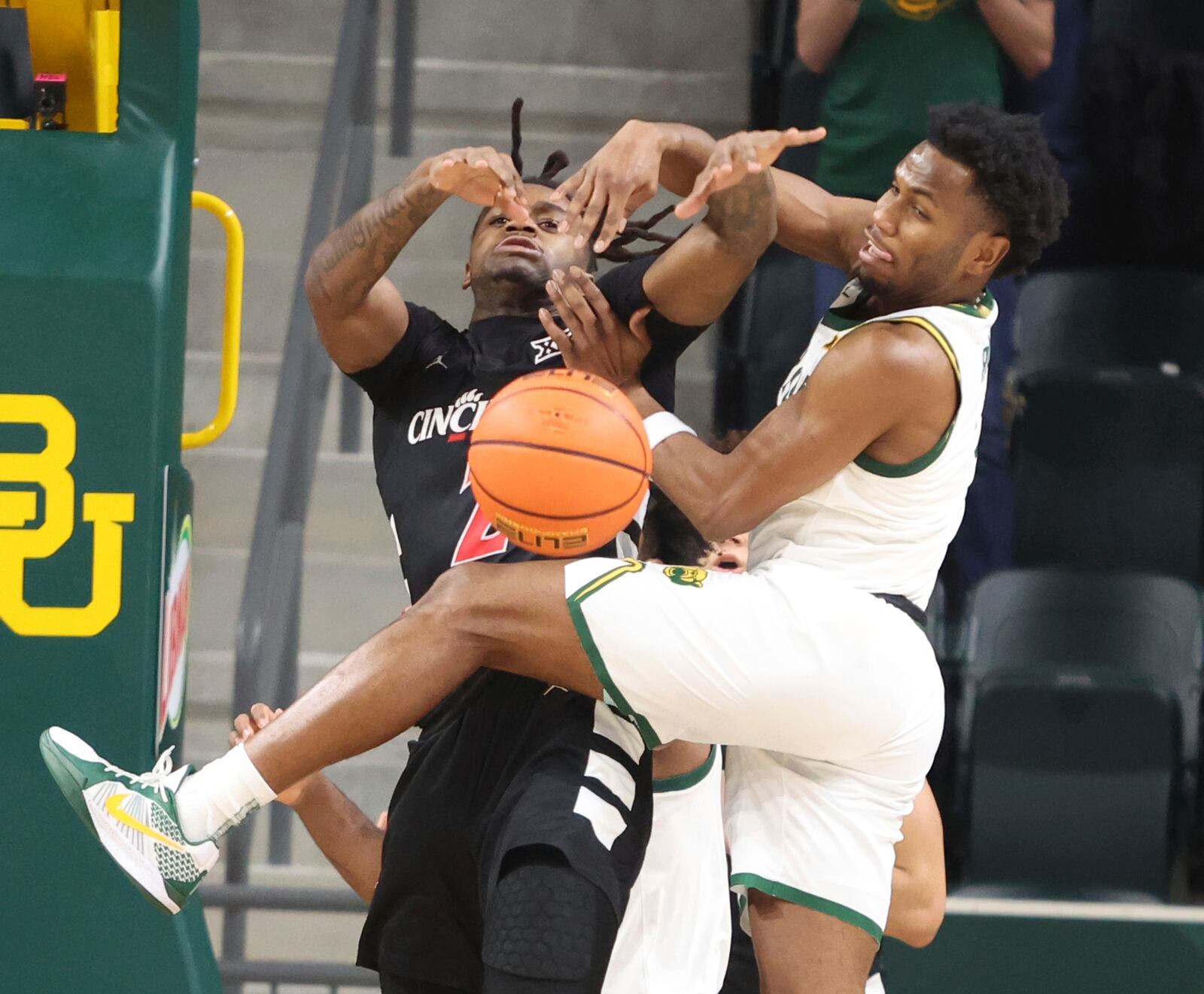 Cincinnati guard Jizzle James battles Baylor guard Jeremy Roach for a loose ball in the first half of an NCAA college basketball game, Tuesday, Jan. 7, 2025, in Waco, Texas. (Rod Aydelotte/Waco Tribune-Herald via AP)