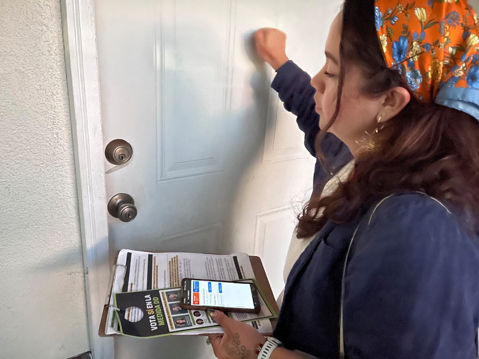 File - Tania Ortega, 27, knocks on the door of a Santa Ana, Calif. resident on Wednesday, Oct. 23, 2024, talk talk about Measure DD, which would allow noncitizens to vote in local elections. (AP Photo/Jaimie Ding, File)